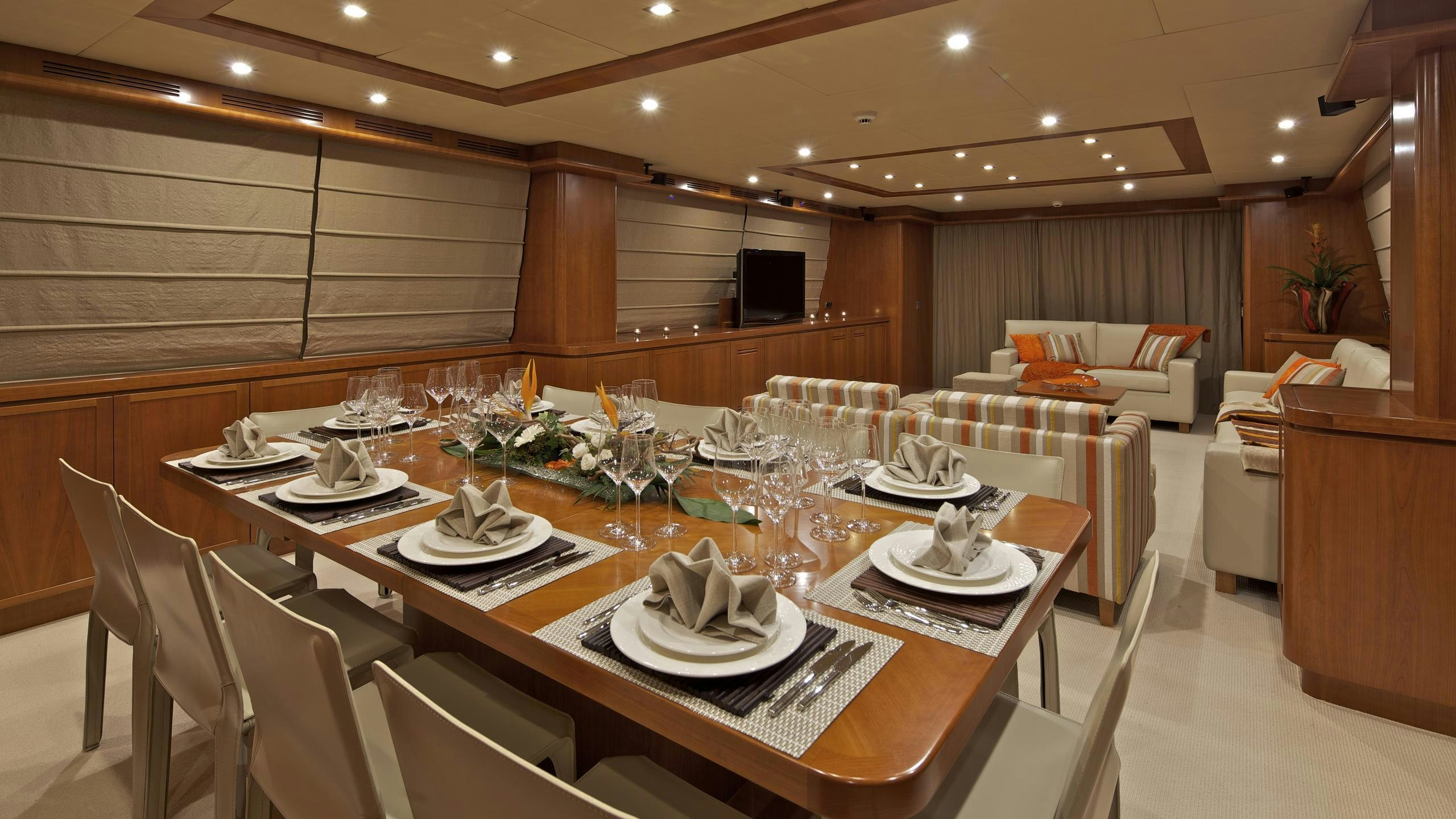 a large dining room with a table set for a dinner aboard HELIOS Yacht for Charter