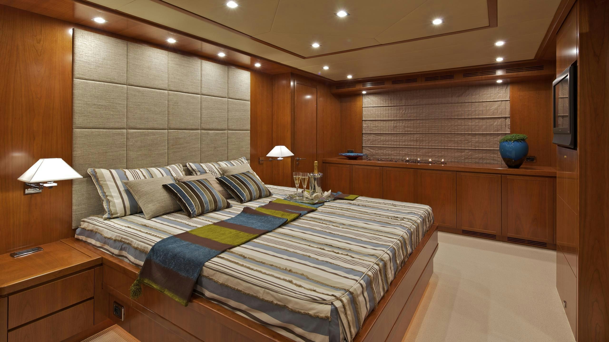 a room with a bed and a table aboard HELIOS Yacht for Charter