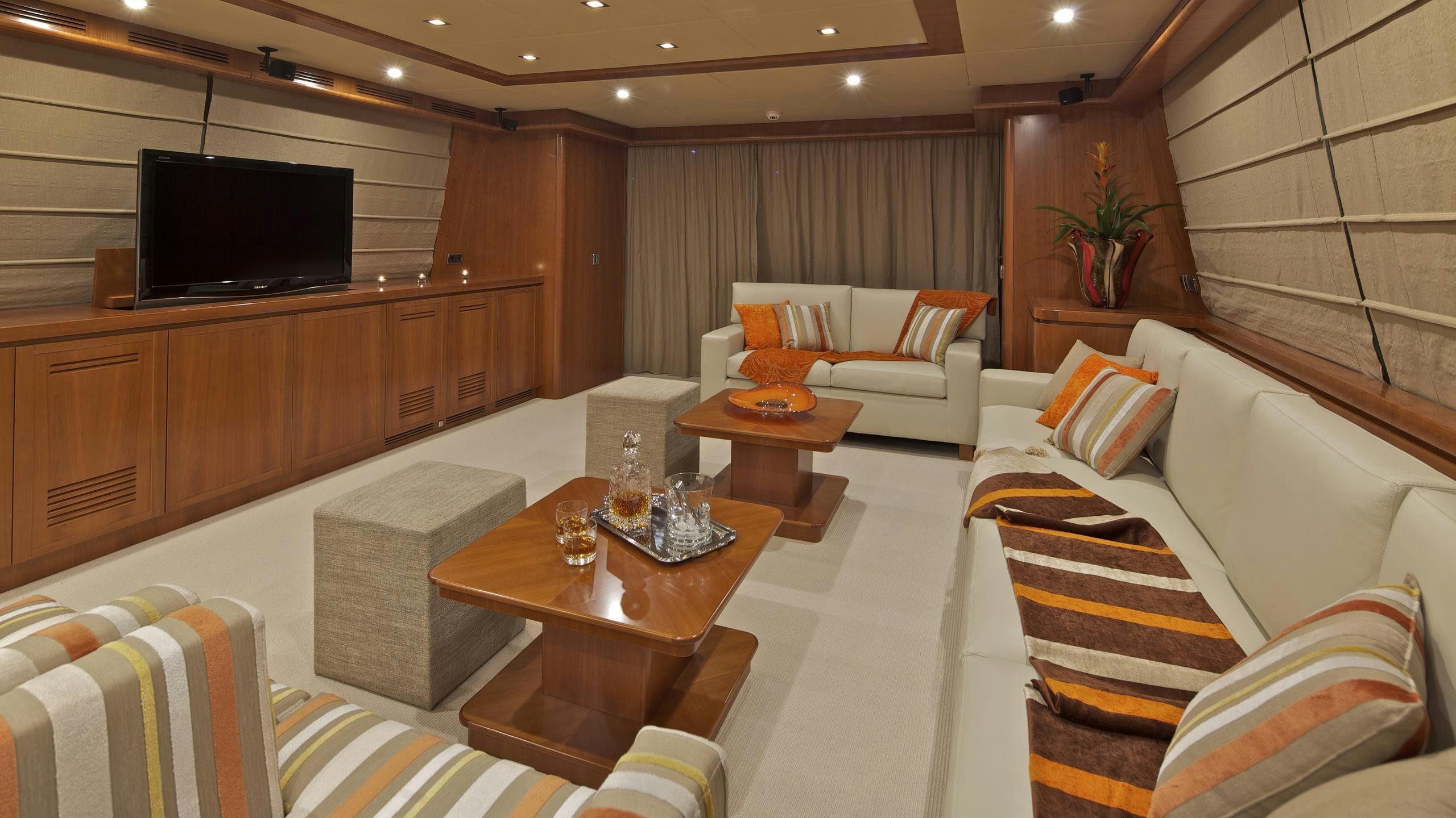 a living room with a couch and a television aboard HELIOS Yacht for Charter