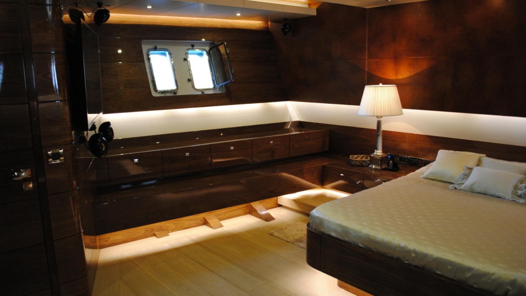 a room with a bed and a desk aboard MUSIC Yacht for Charter