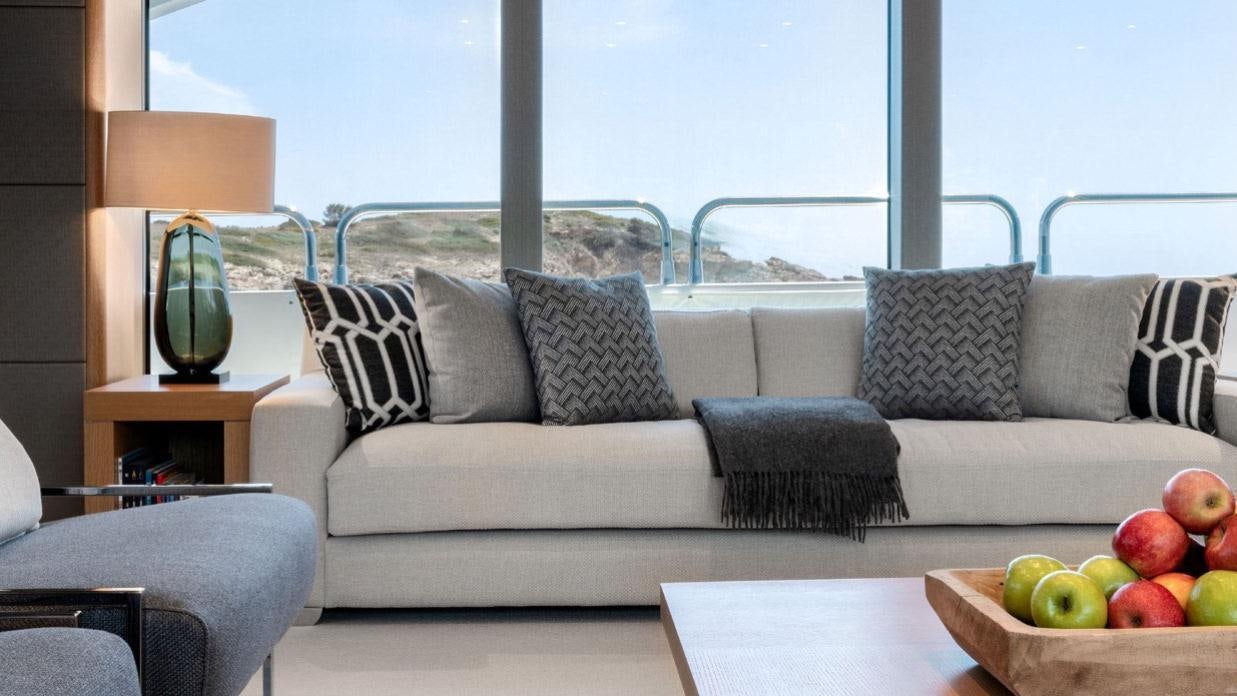 a couch with a bowl of apples on it aboard OKSANCHIK Yacht for Charter