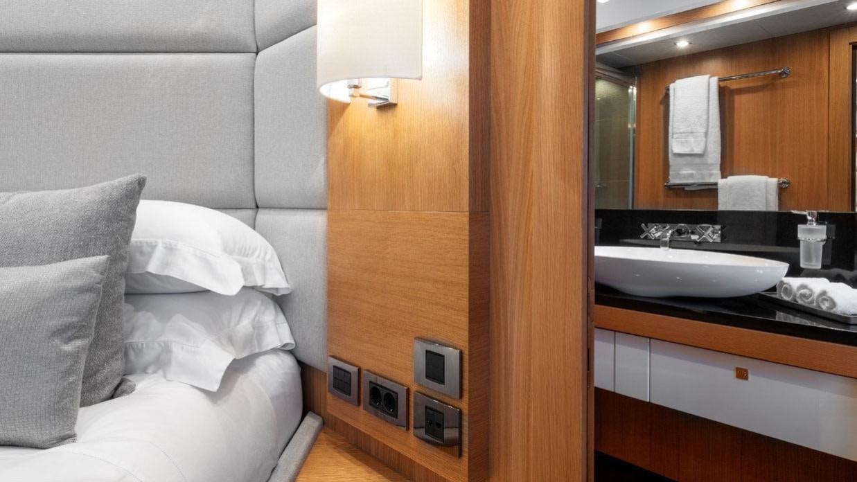 a bed and a mirror in a room aboard OKSANCHIK Yacht for Charter