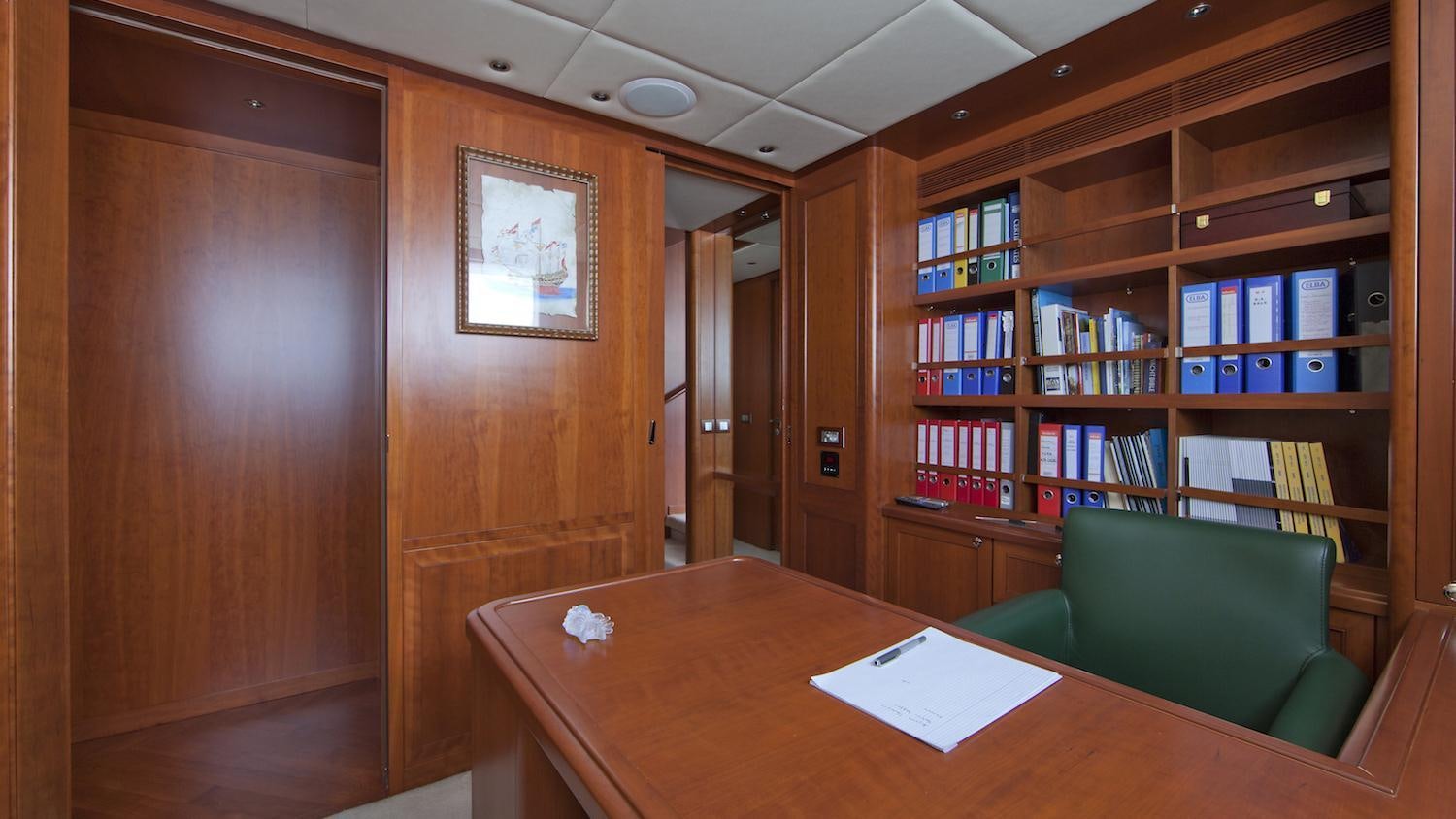 a room with a table and bookshelves aboard CORNELIA Yacht for Charter
