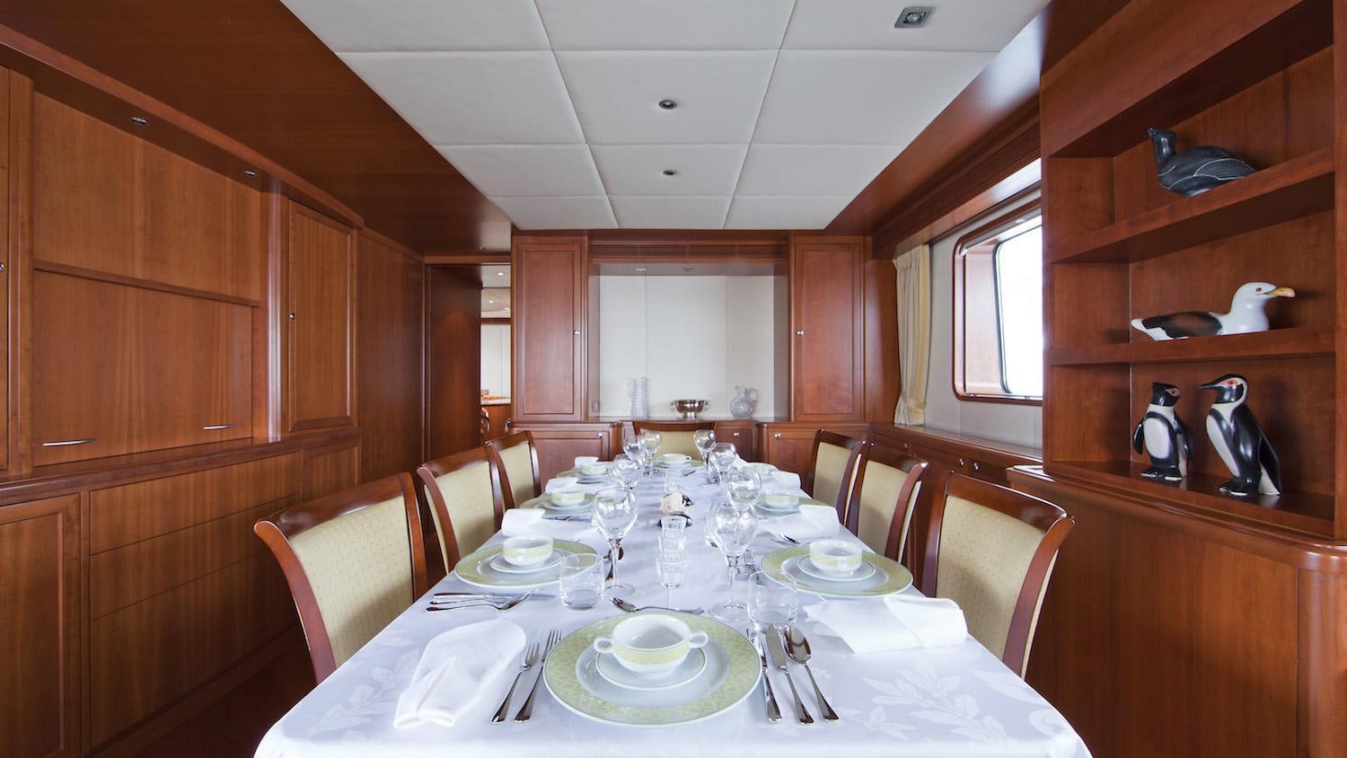 a dining table with plates and silverware aboard CORNELIA Yacht for Charter