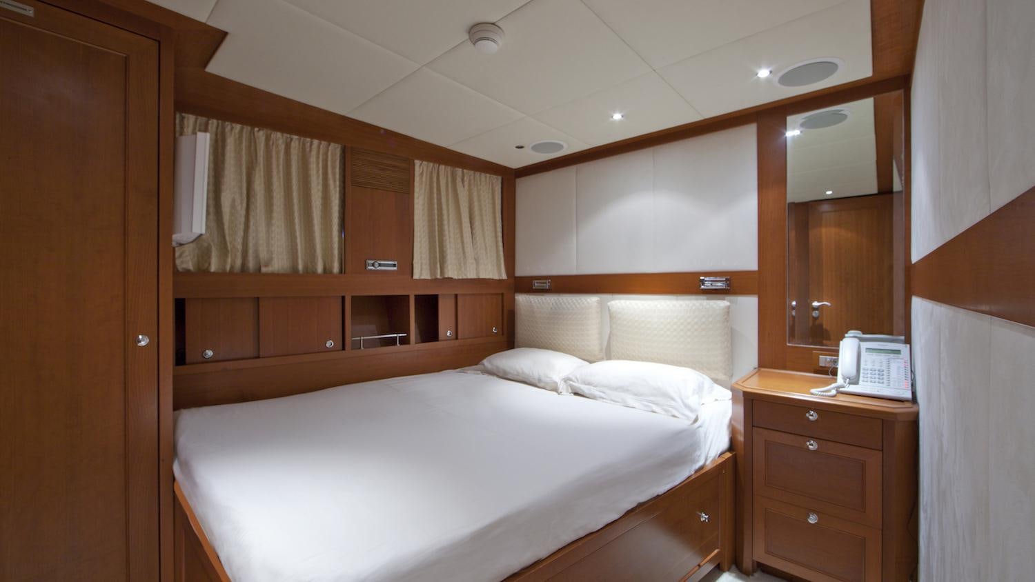 a room with a bed and a phone aboard CORNELIA Yacht for Charter