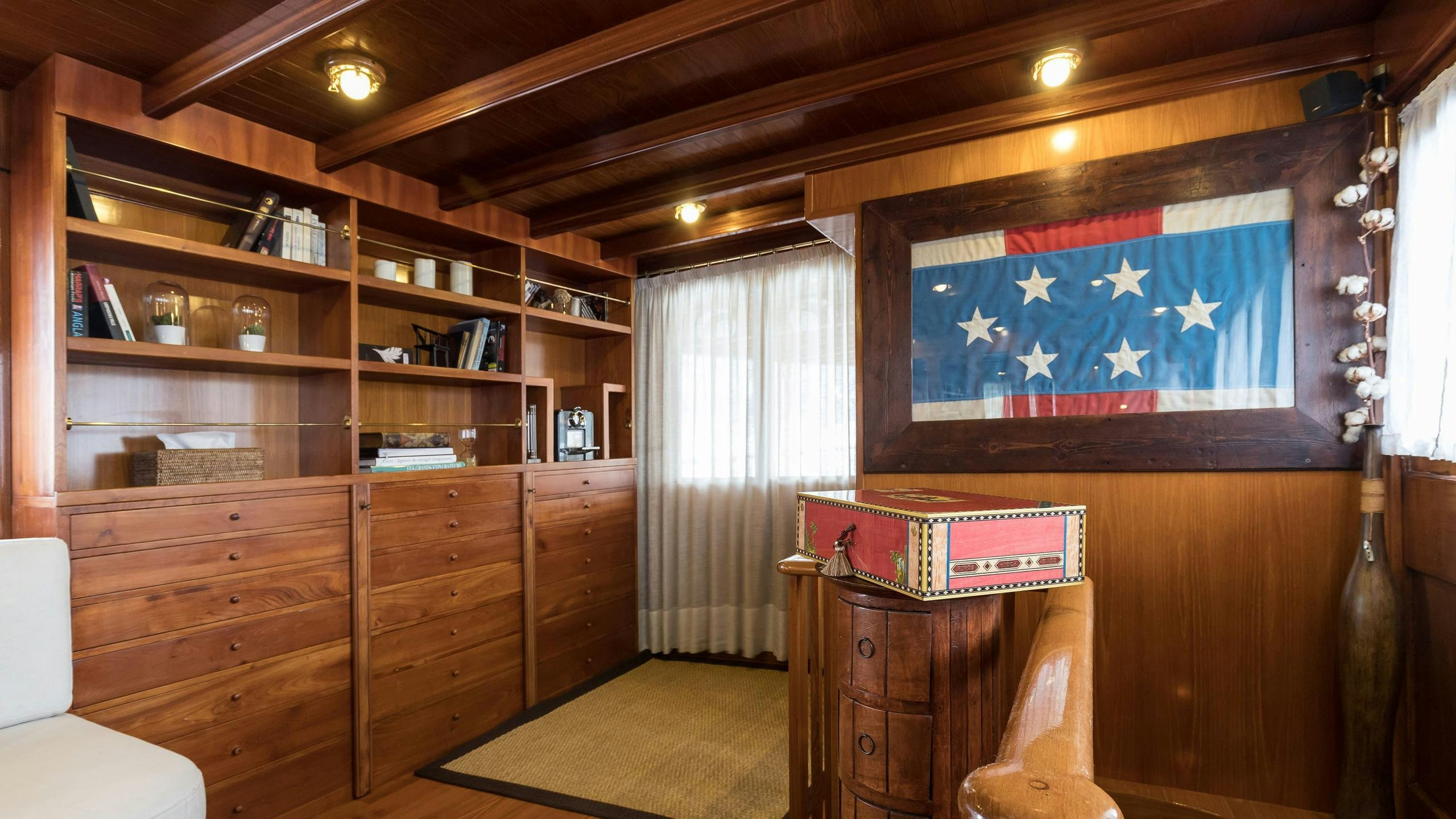 a room with a desk and a shelf with books on it aboard OVER THE RAINBOW OF LONDON Yacht for Charter