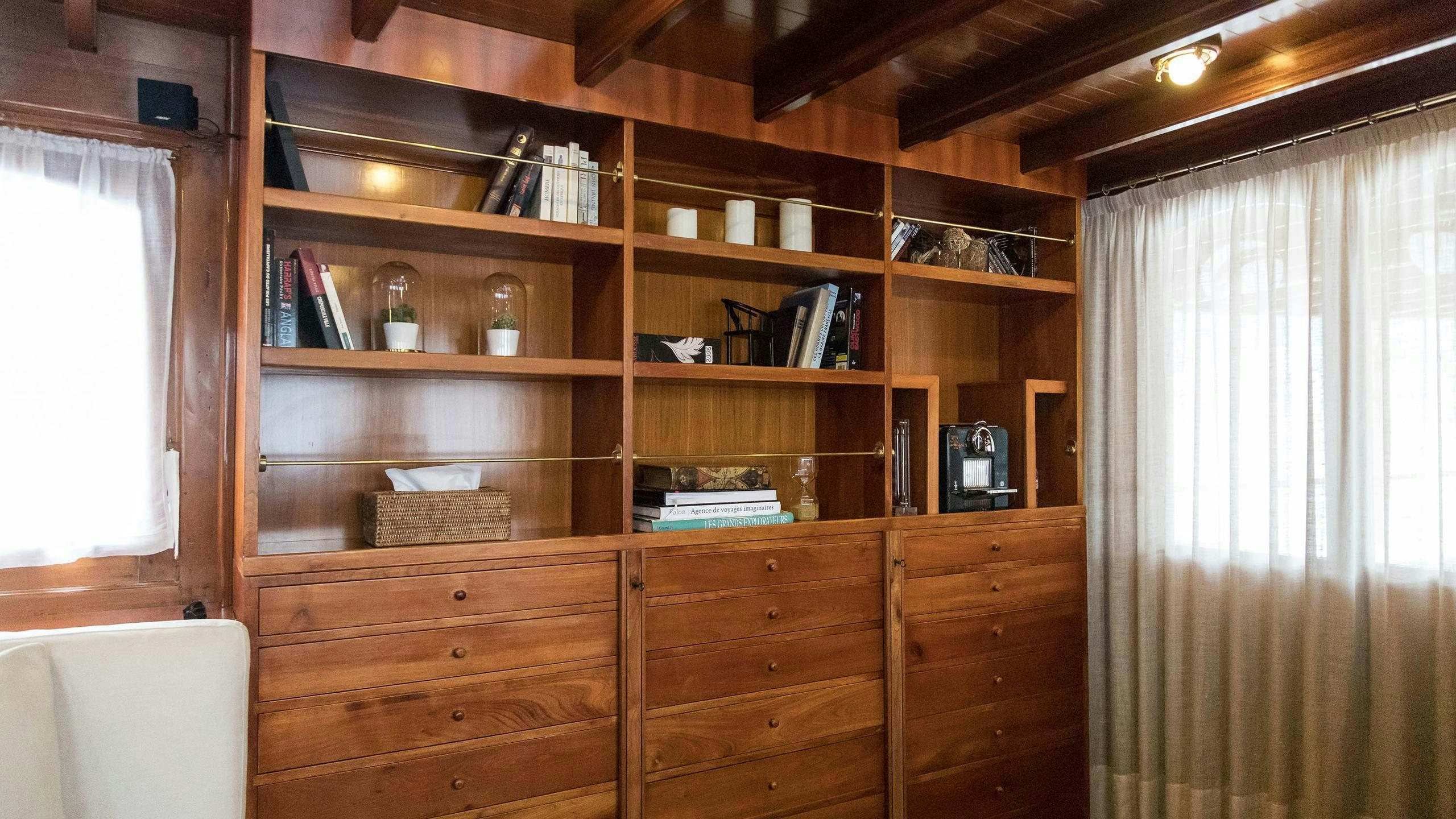 a wooden shelf with books and a window aboard OVER THE RAINBOW OF LONDON Yacht for Charter