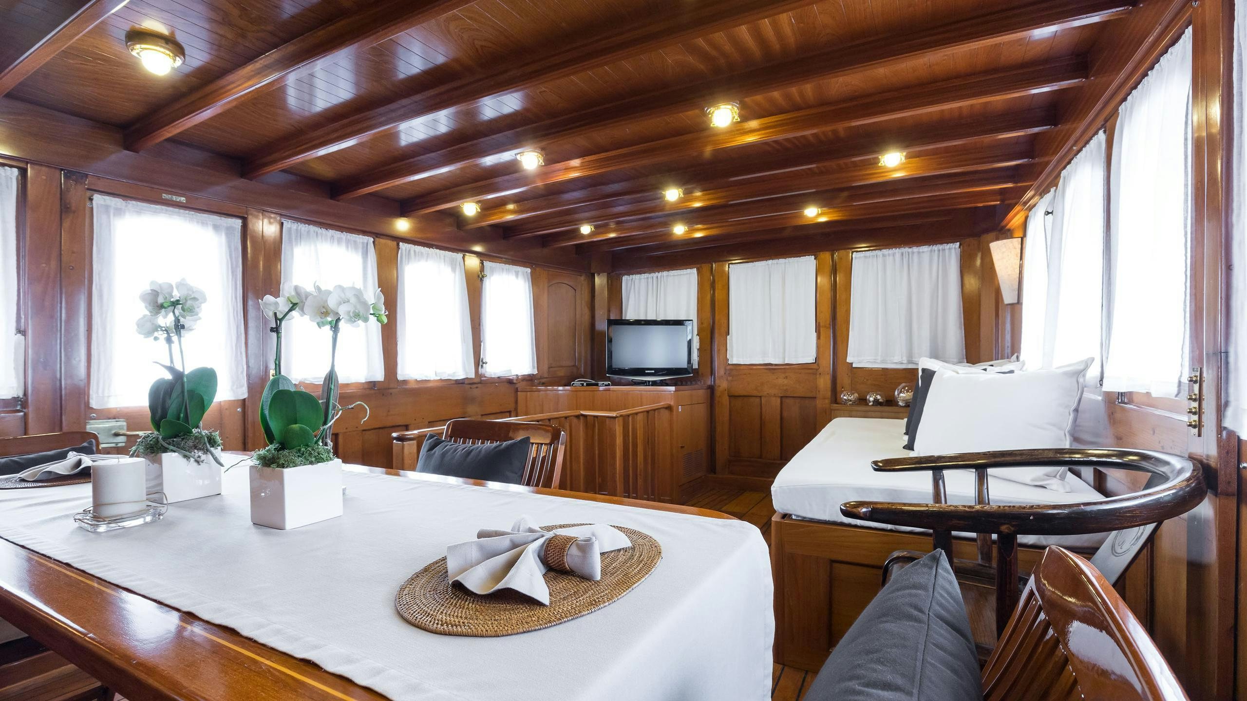 a room with a table and chairs aboard OVER THE RAINBOW OF LONDON Yacht for Charter