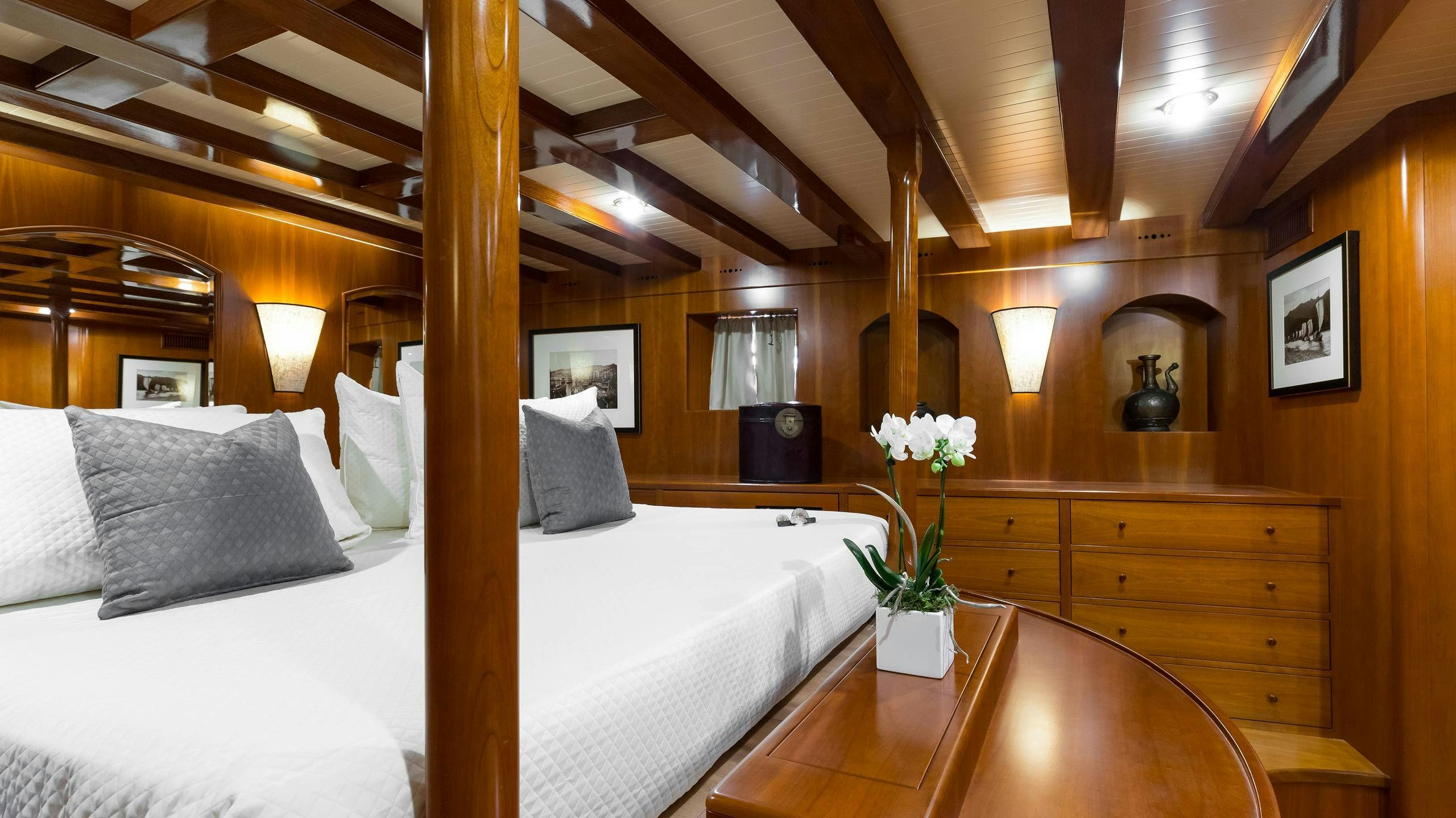 a bed with white sheets and pillows aboard OVER THE RAINBOW OF LONDON Yacht for Charter