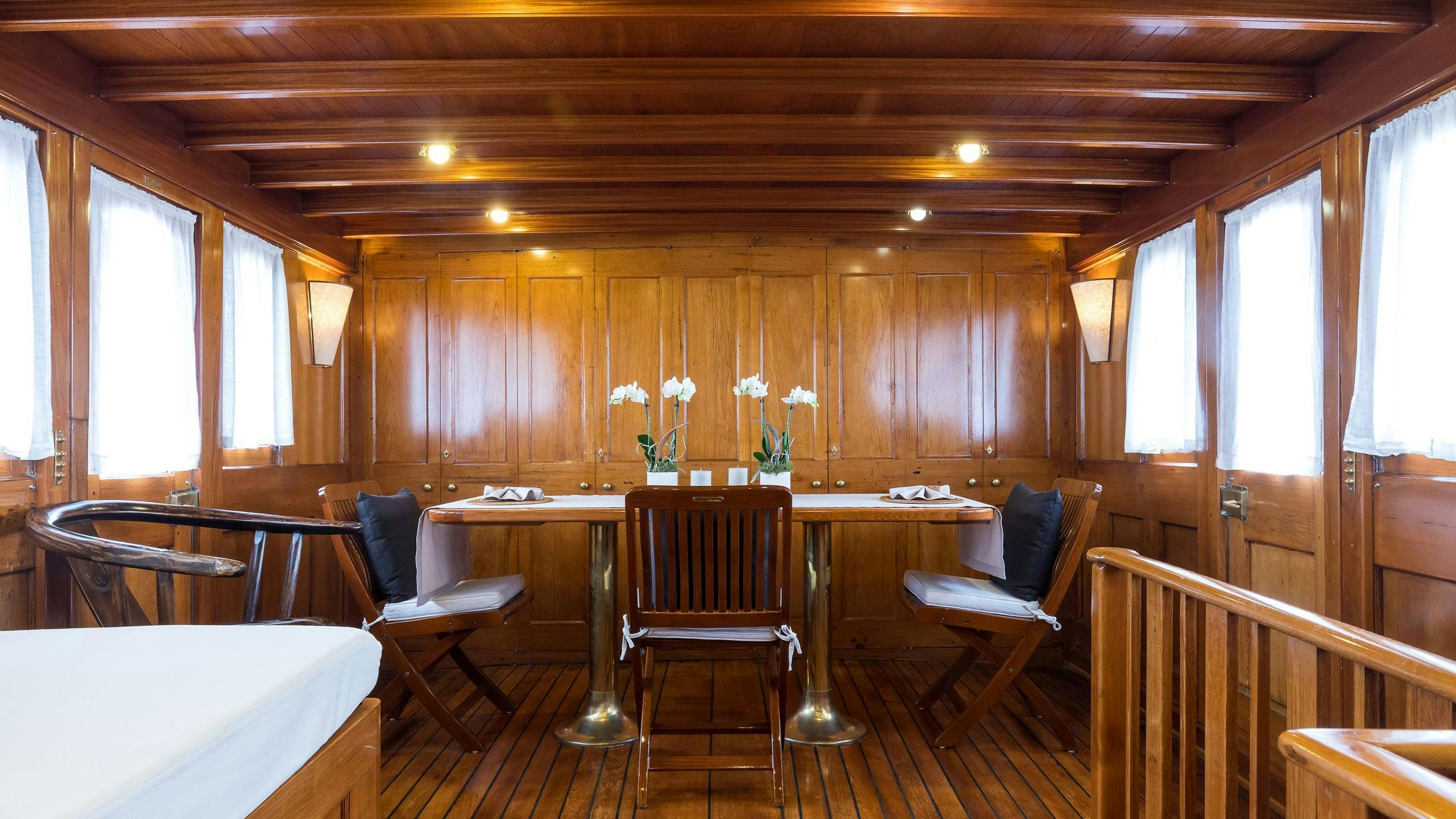 a room with tables and chairs aboard OVER THE RAINBOW OF LONDON Yacht for Charter