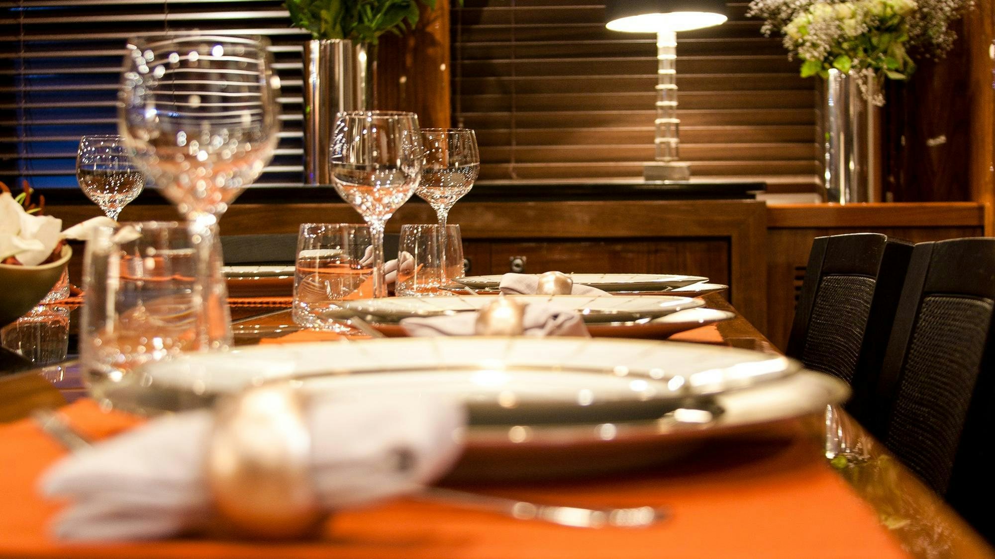 a table with wine glasses and food on it aboard ARAGO Yacht for Charter