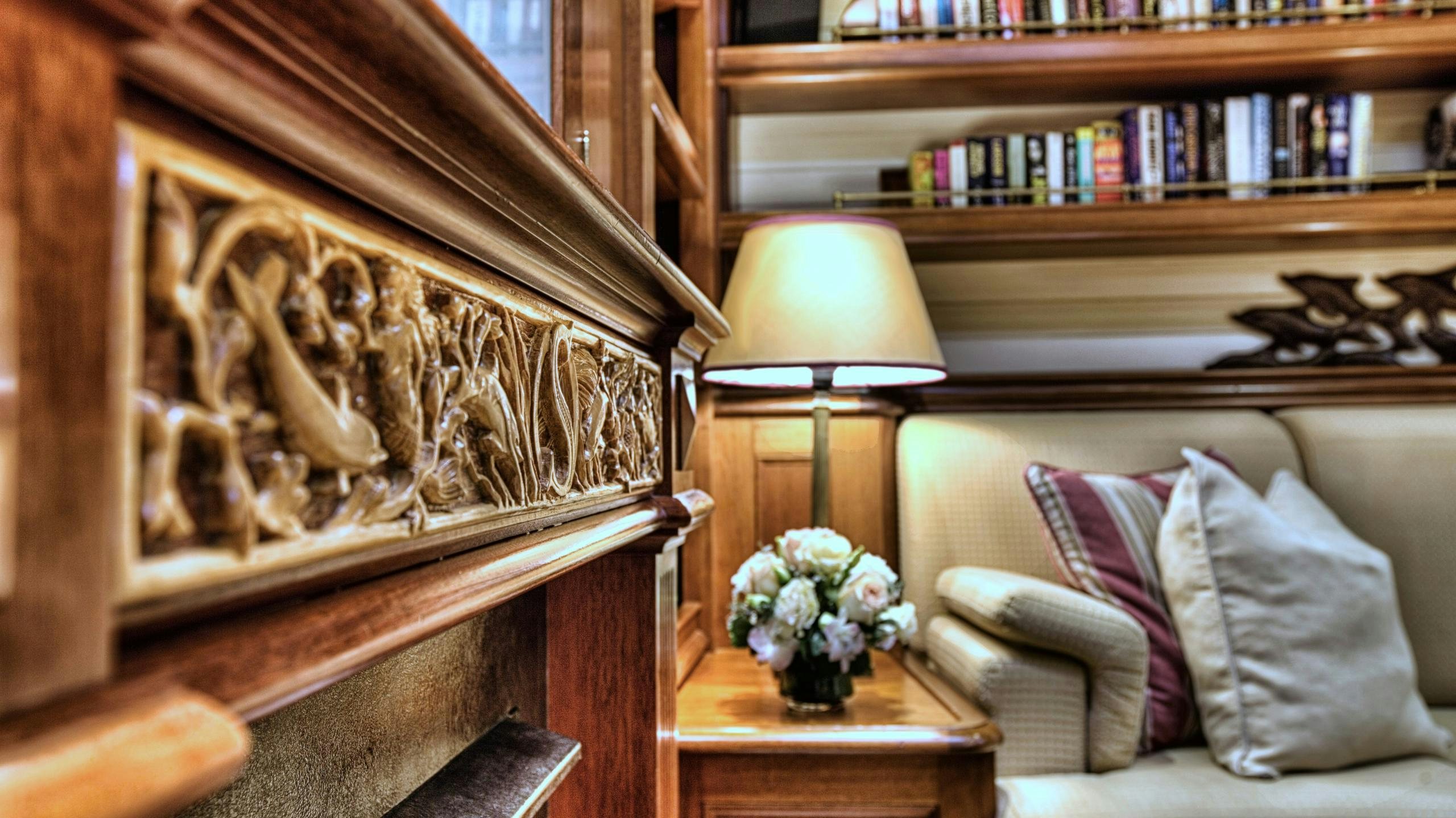 a room with a couch and a lamp and a bookcase aboard SHAMOUN Yacht for Charter