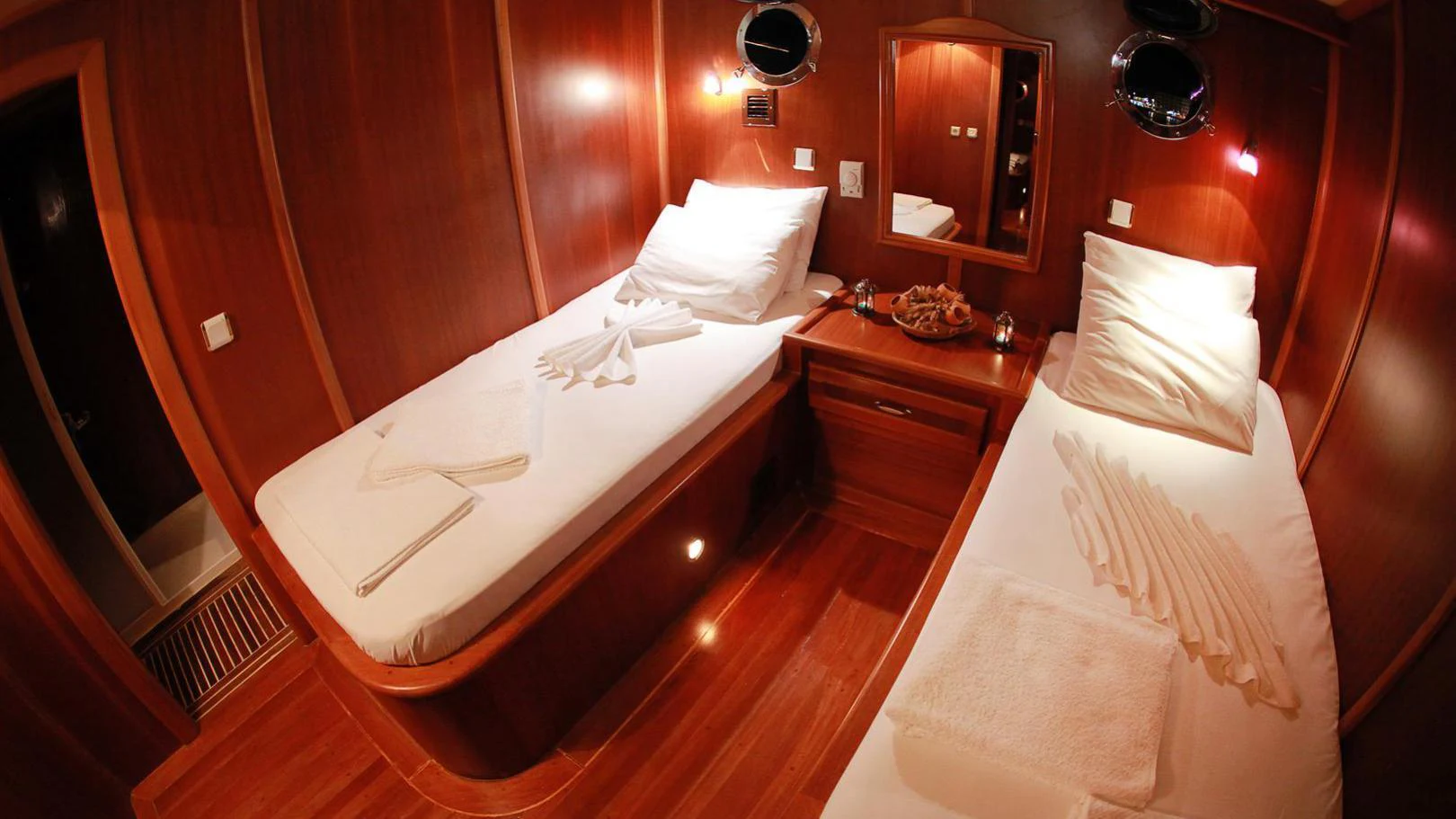 a hotel room with a bed and a mirror aboard JUNIOR ORCUN Yacht for Charter