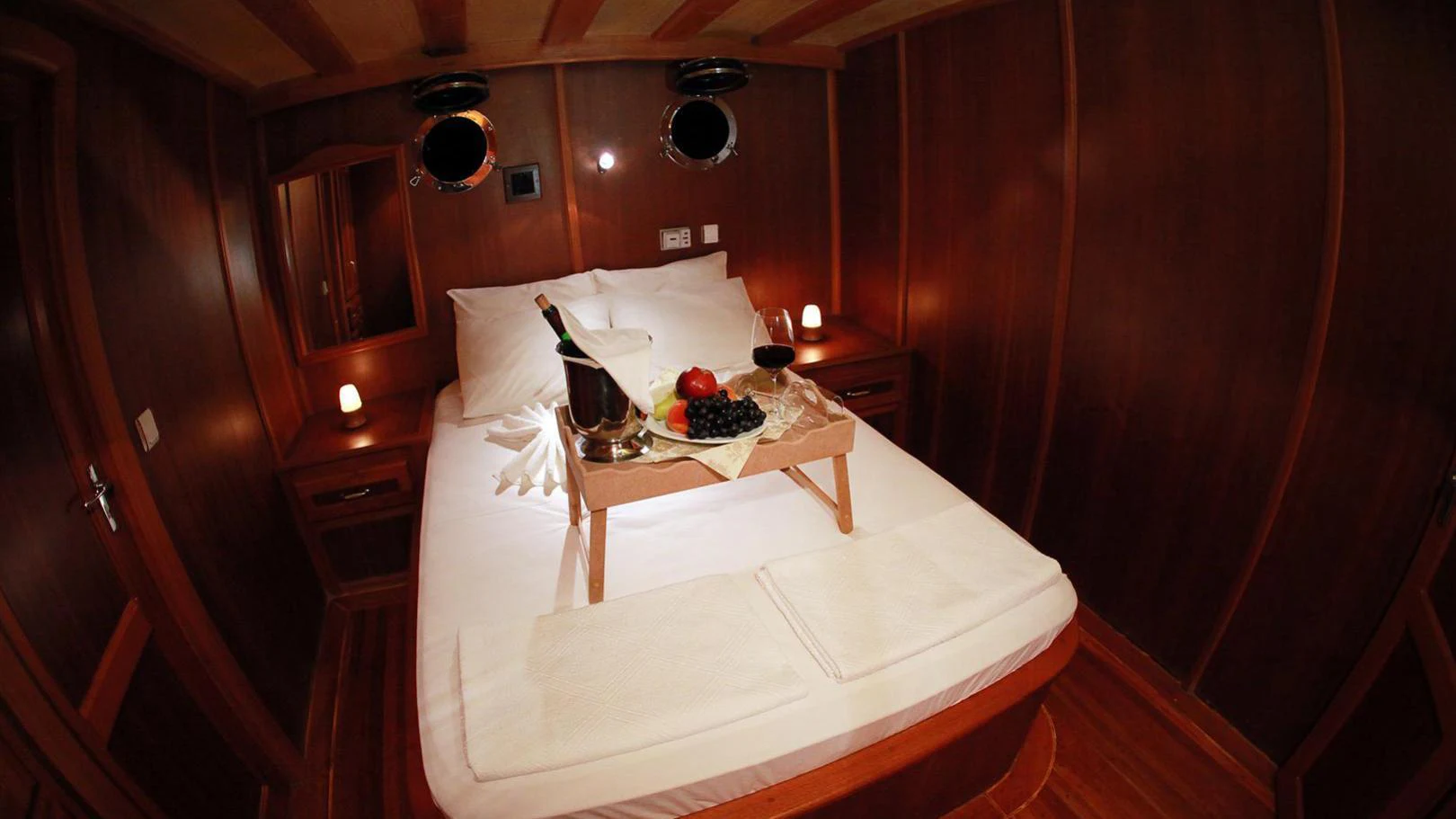 a bed with a tray of food on it aboard JUNIOR ORCUN Yacht for Charter