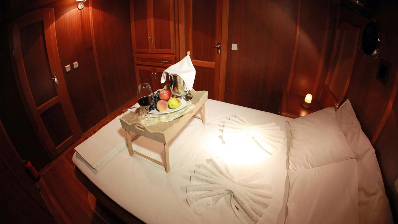 a bed with a tray of food on it aboard JUNIOR ORCUN Yacht for Charter