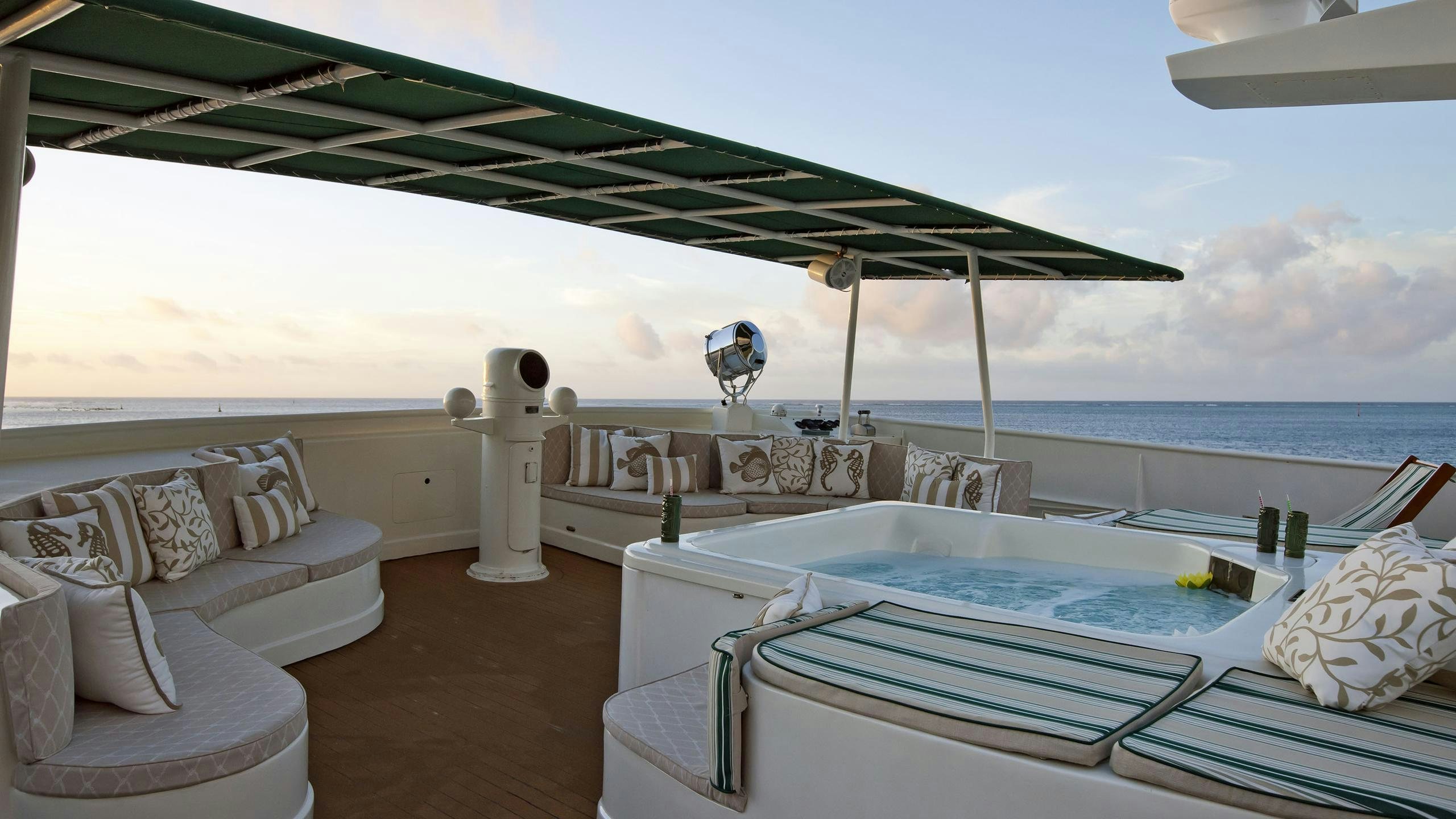 a lounge area with a large lounge chair and a large umbrella aboard ASKARI Yacht for Charter