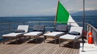 a deck with chairs and umbrellas aboard PERSUADER Yacht for Charter