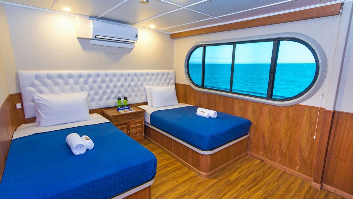 a room with beds and a window aboard TIP TOP II Yacht for Charter