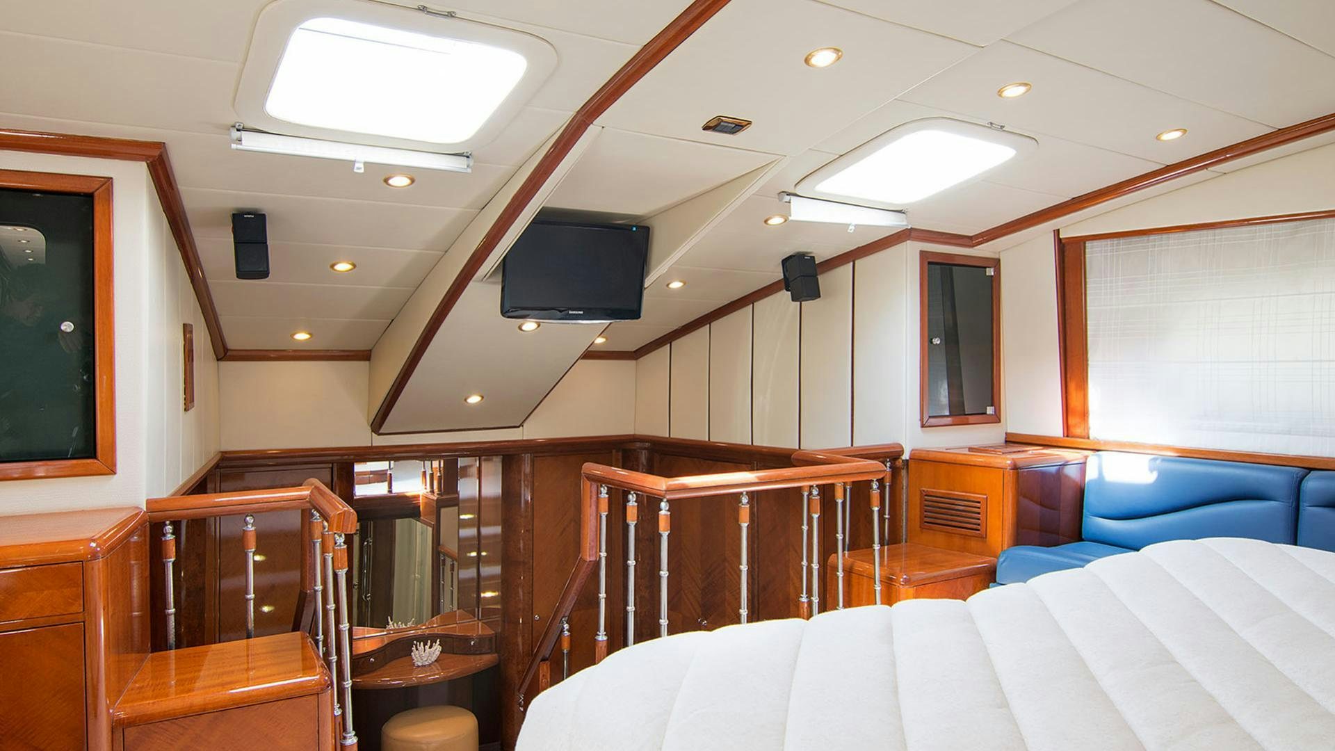 a room with a bed and a tv on the wall aboard DREAM B Yacht for Charter
