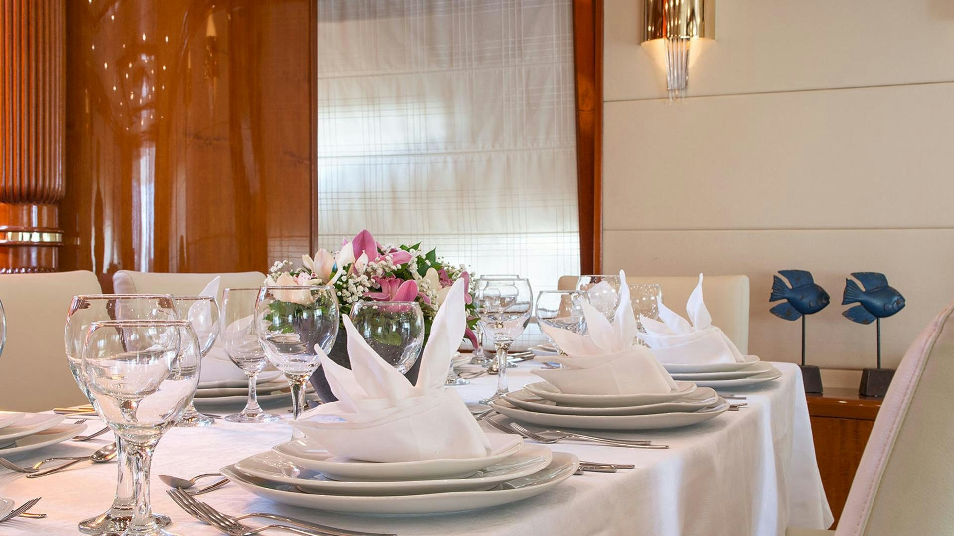 a table set with plates and glasses aboard DREAM B Yacht for Charter
