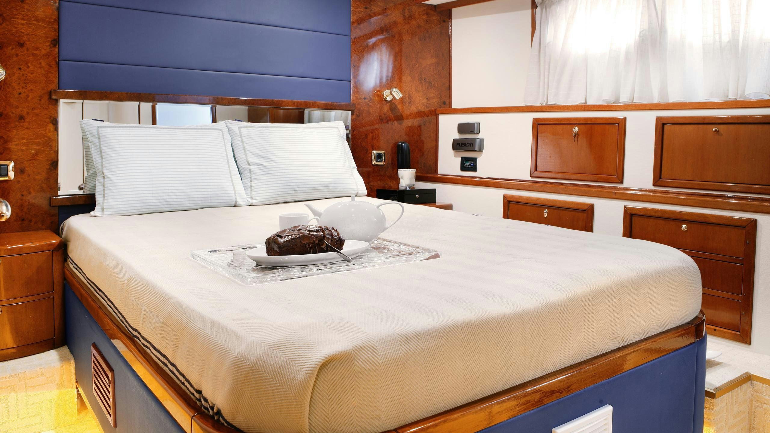a bed with a white sheet and pillows on it aboard DREAM B Yacht for Charter