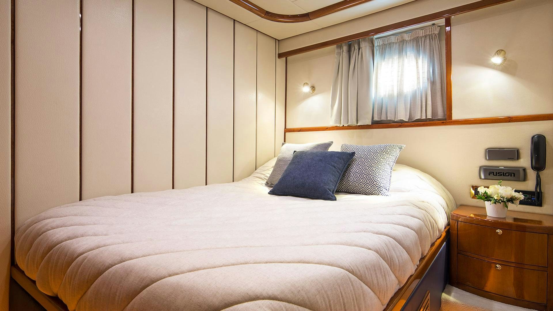 a bed with a white sheet and pillows aboard DREAM B Yacht for Charter