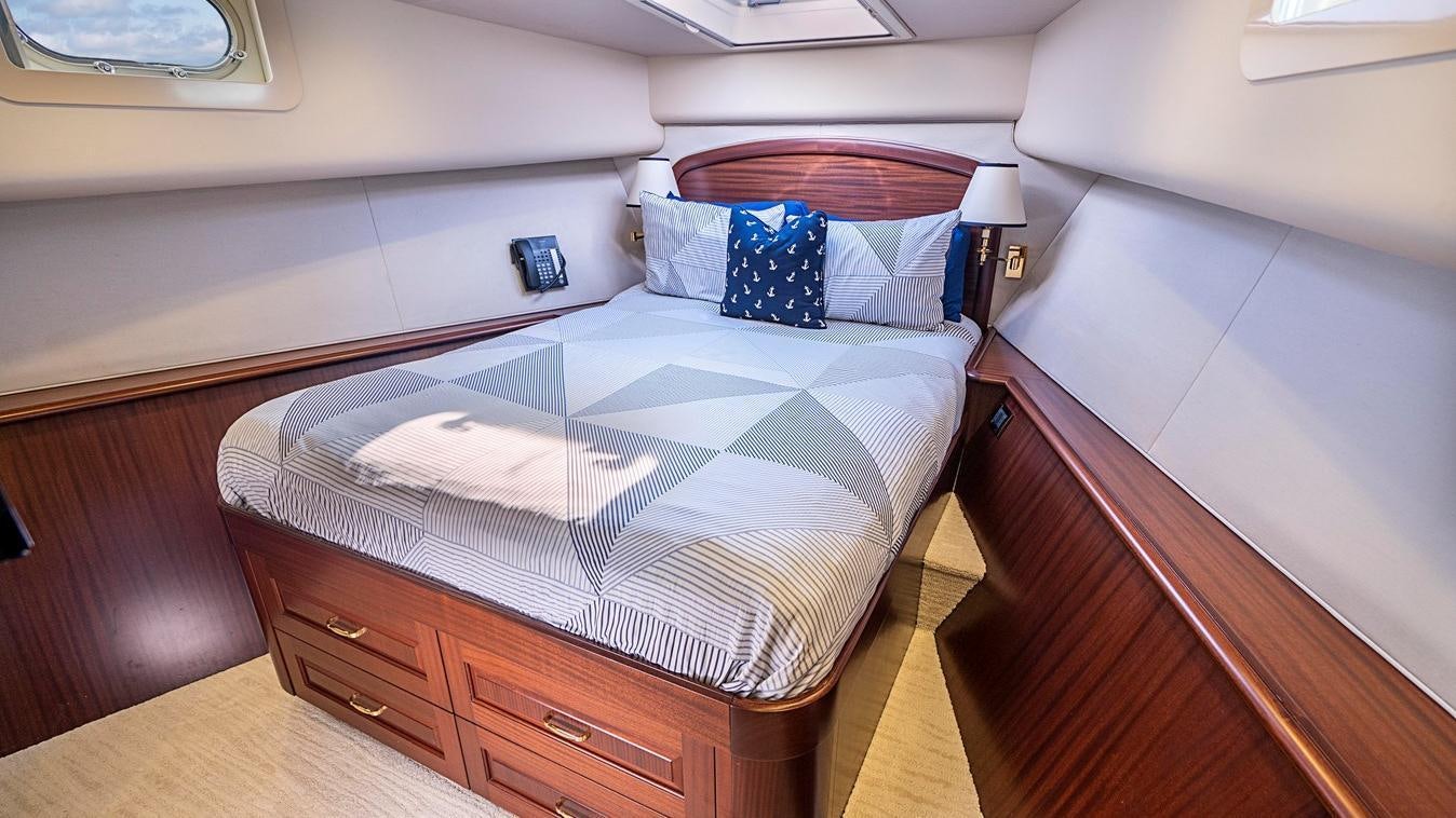 a bed with a blue pillow aboard TRANQUILITY Yacht for Charter