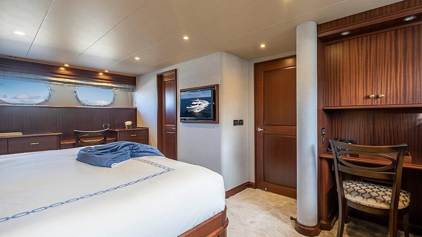 a bedroom with a bed and a chair aboard TRANQUILITY Yacht for Charter
