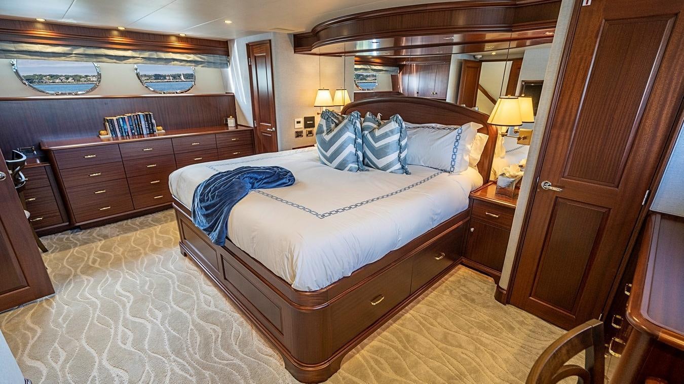 a bedroom with a bed and a dresser aboard TRANQUILITY Yacht for Charter