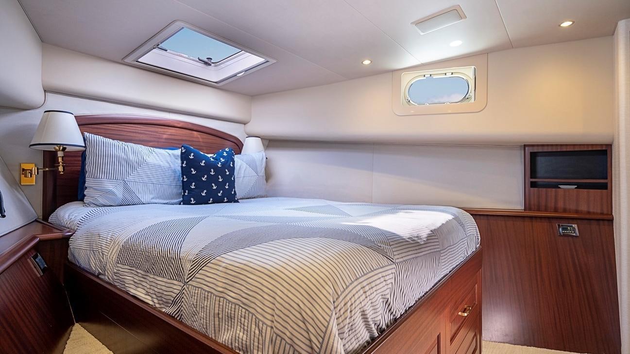 a bed with blue pillows aboard TRANQUILITY Yacht for Charter