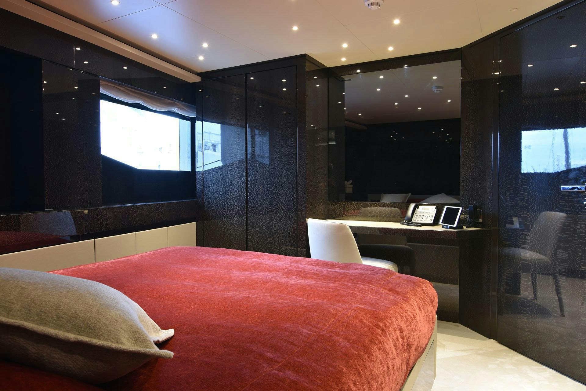 a room with a bed and desk aboard MY EDEN Yacht for Charter