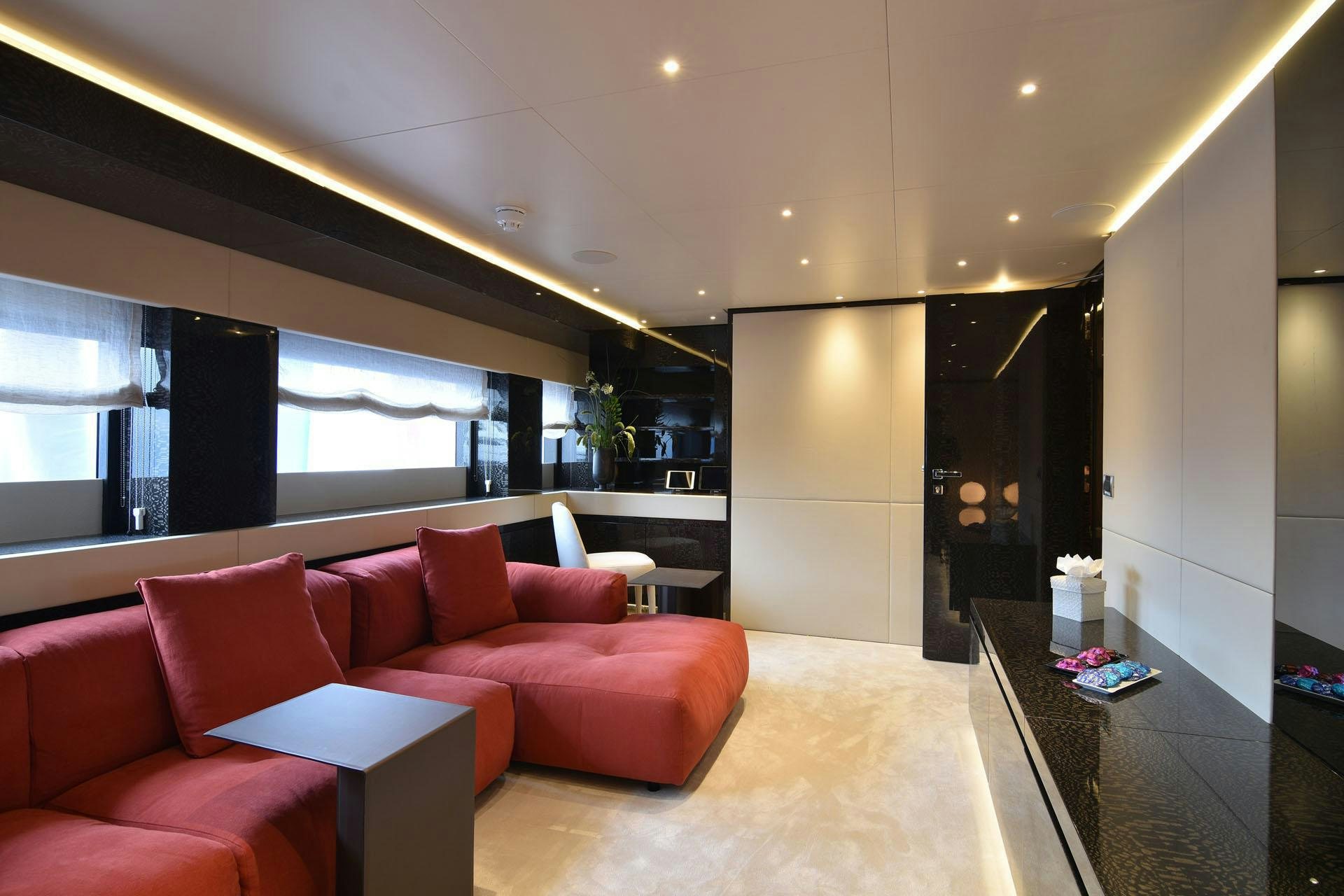 a living room with red couches aboard MY EDEN Yacht for Charter