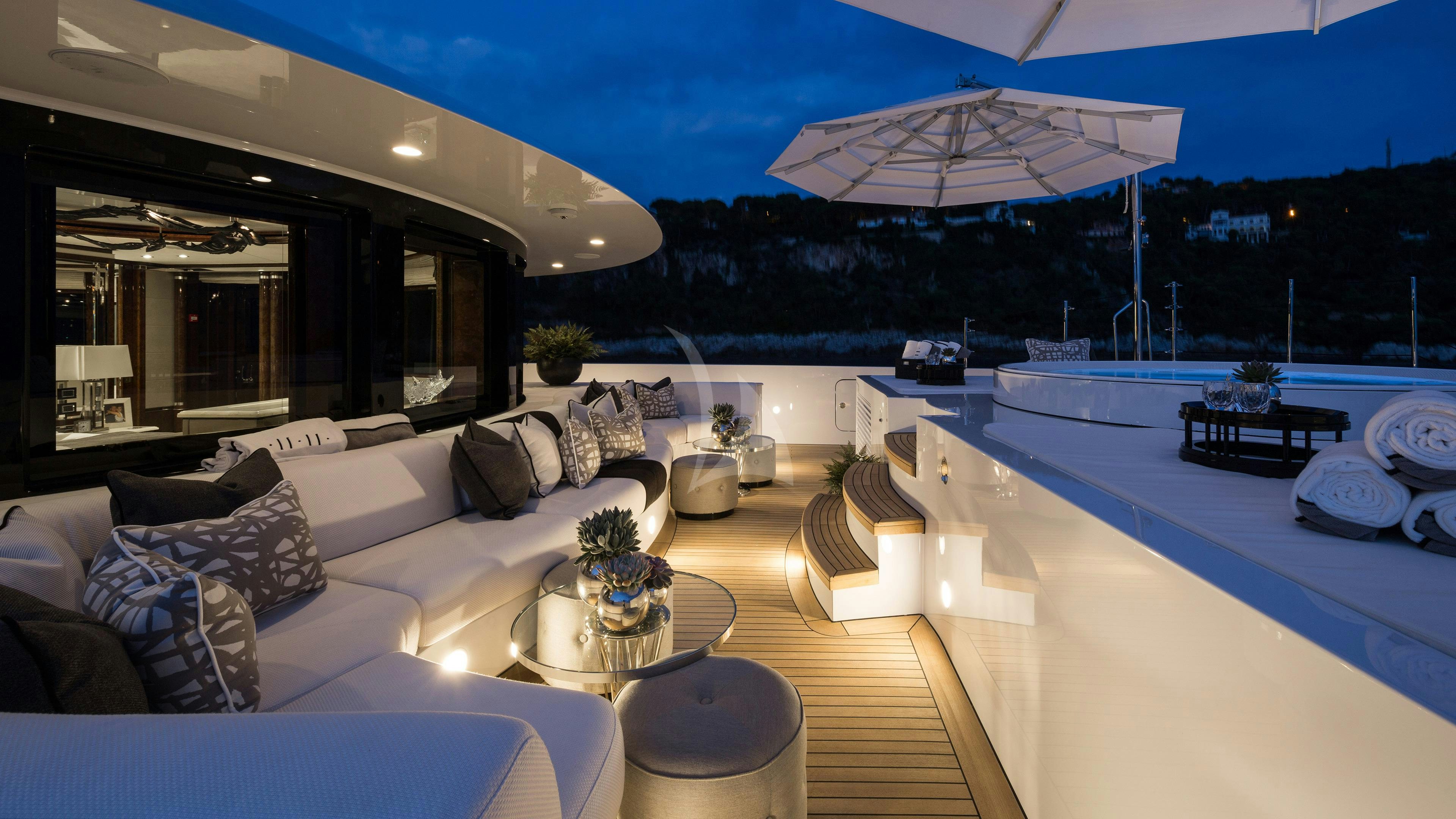 a large living room with a large swimming pool and a large patio with a large white umbrella and aboard SOUNDWAVE Yacht for Charter