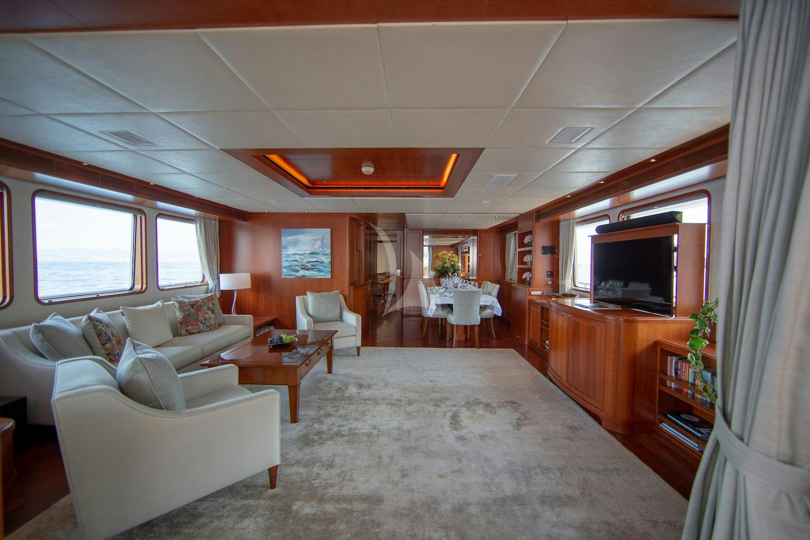 a living room with a large white couch and a television aboard CORNELIA Yacht for Charter