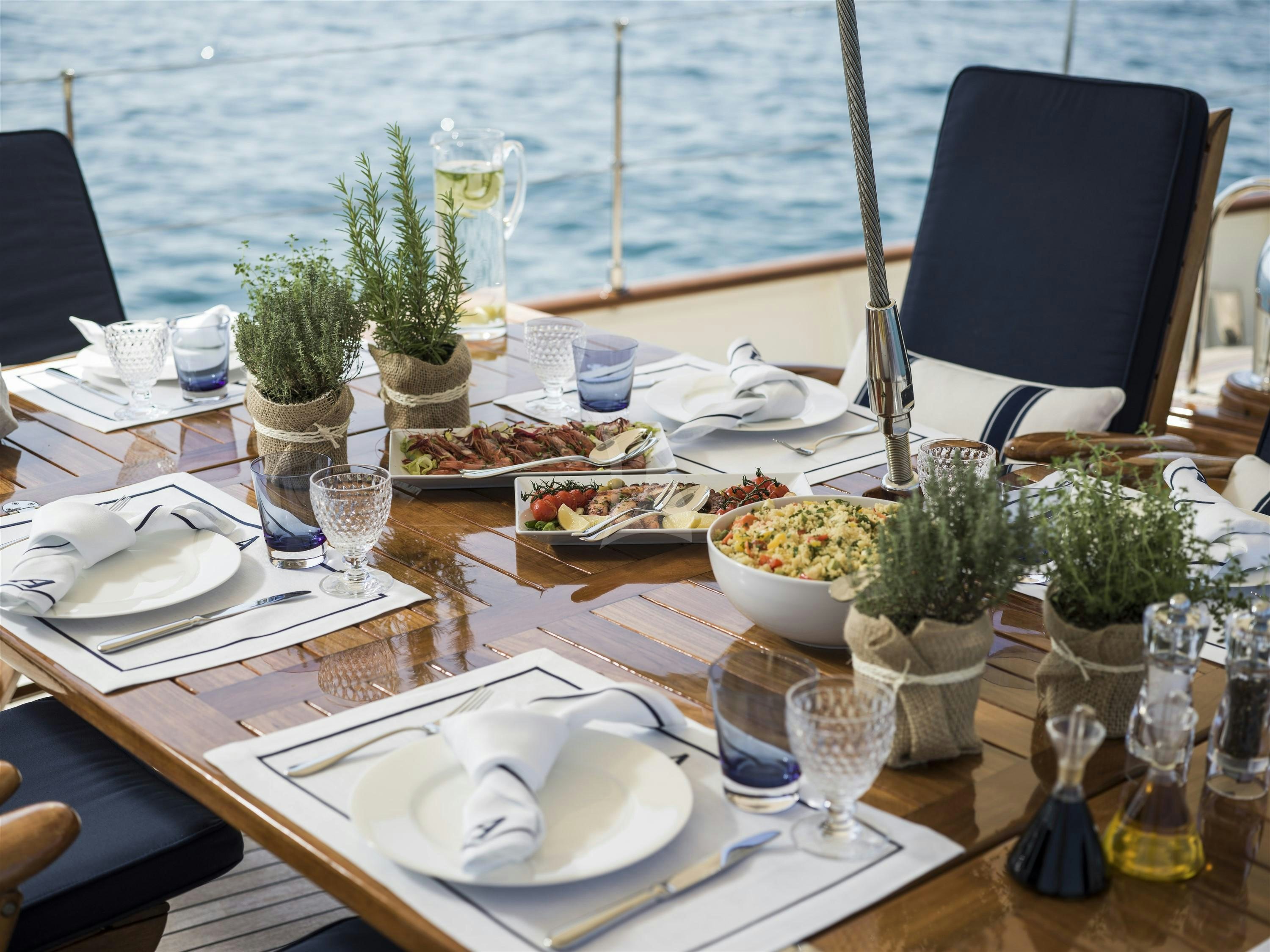 a table set with food and drinks aboard ALEXA OF LONDON Yacht for Charter