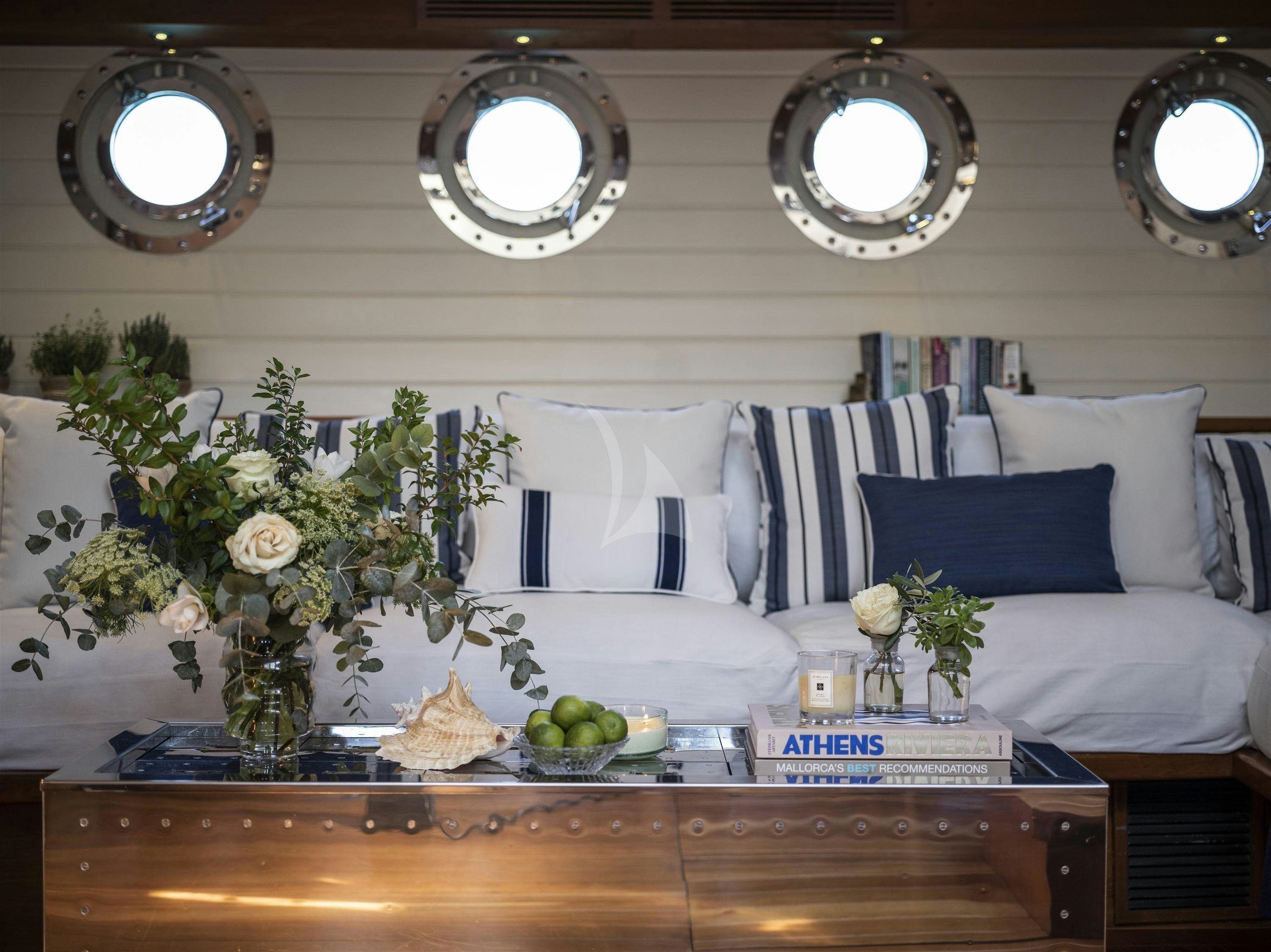 a living room with a white couch and a round mirror aboard ALEXA OF LONDON Yacht for Charter