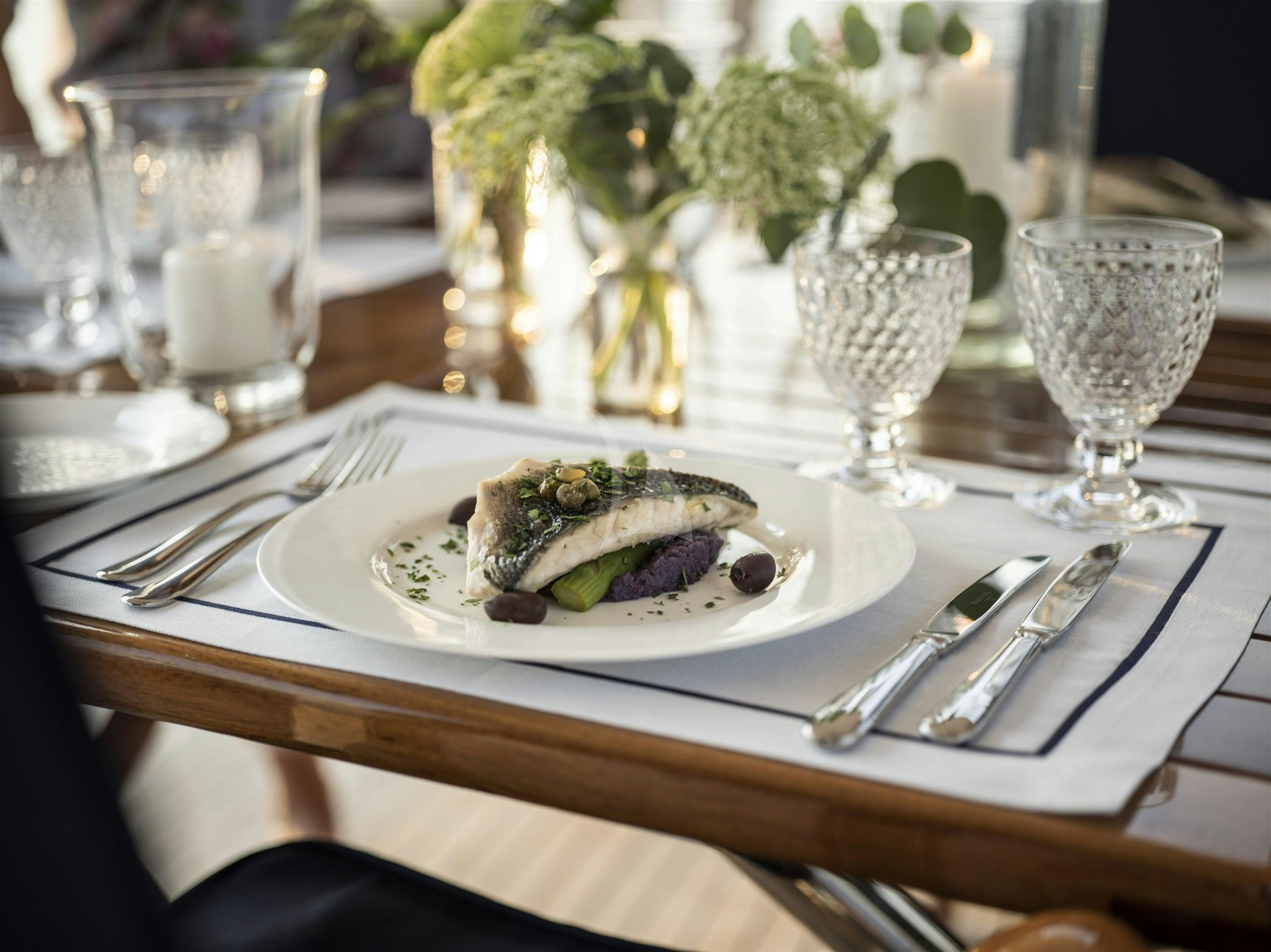 a plate of food and glasses aboard ALEXA OF LONDON Yacht for Charter