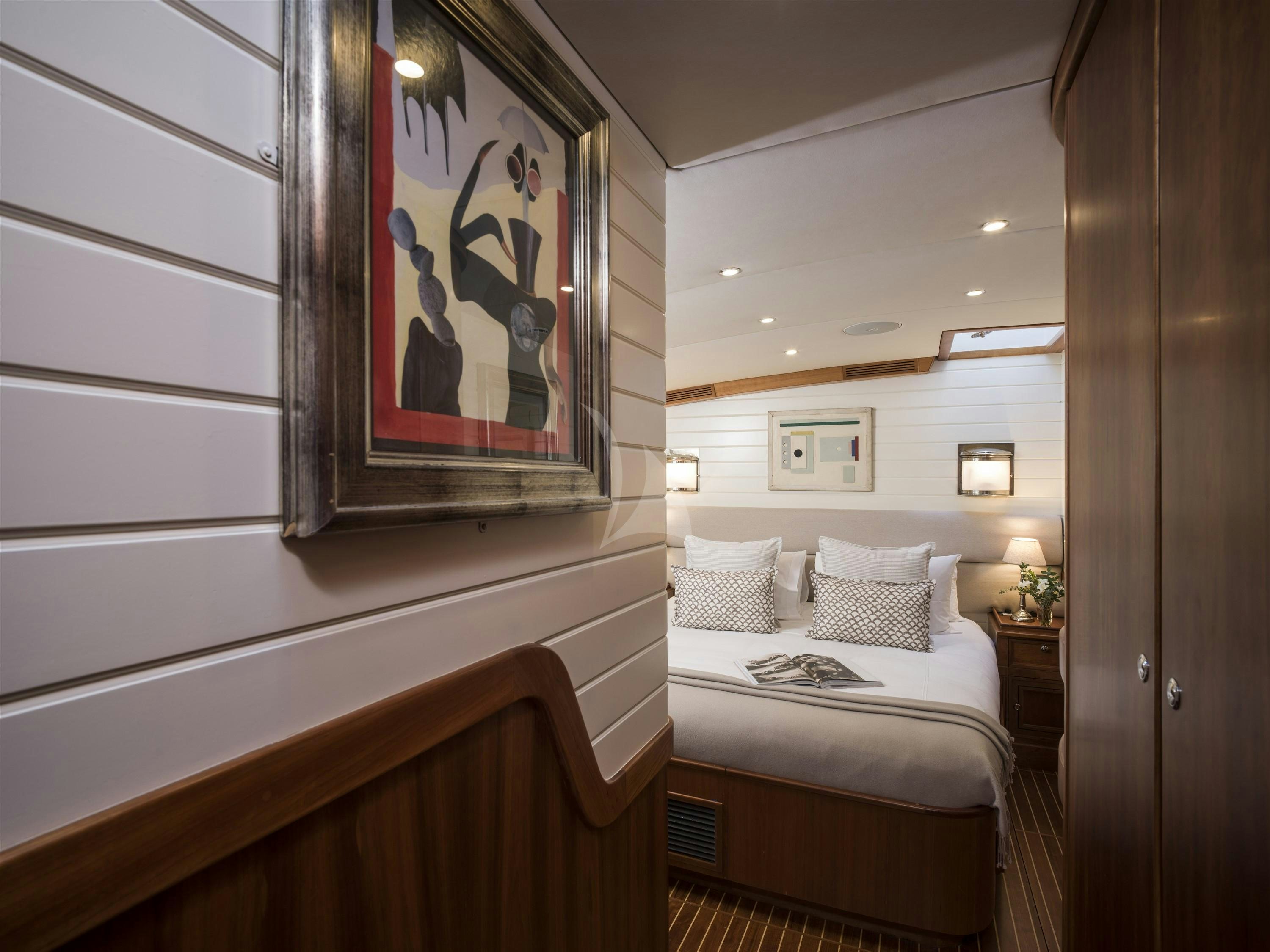 a bedroom with a painting on the wall aboard ALEXA OF LONDON Yacht for Charter