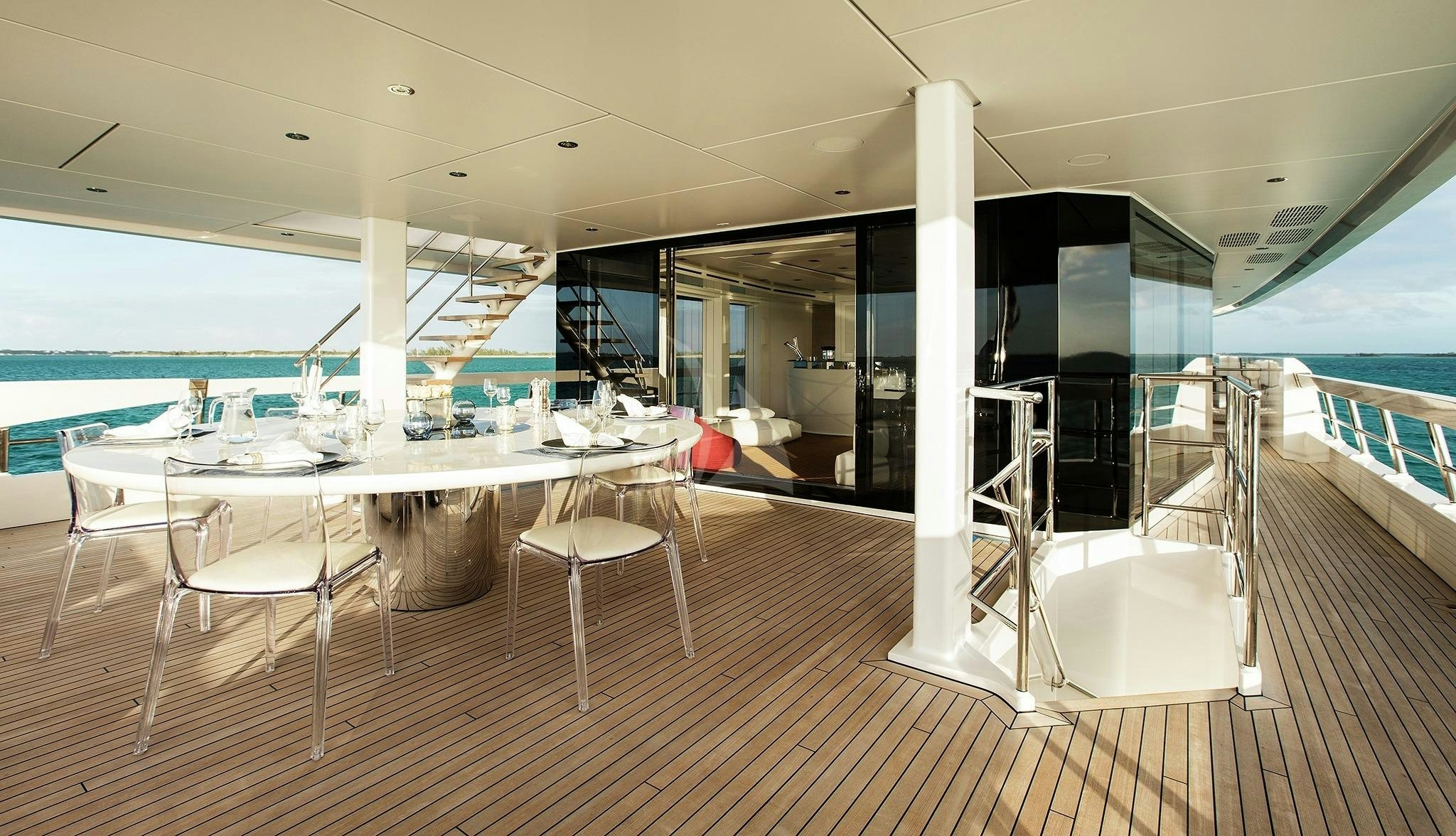 a room with tables and chairs aboard HOME Yacht for Sale