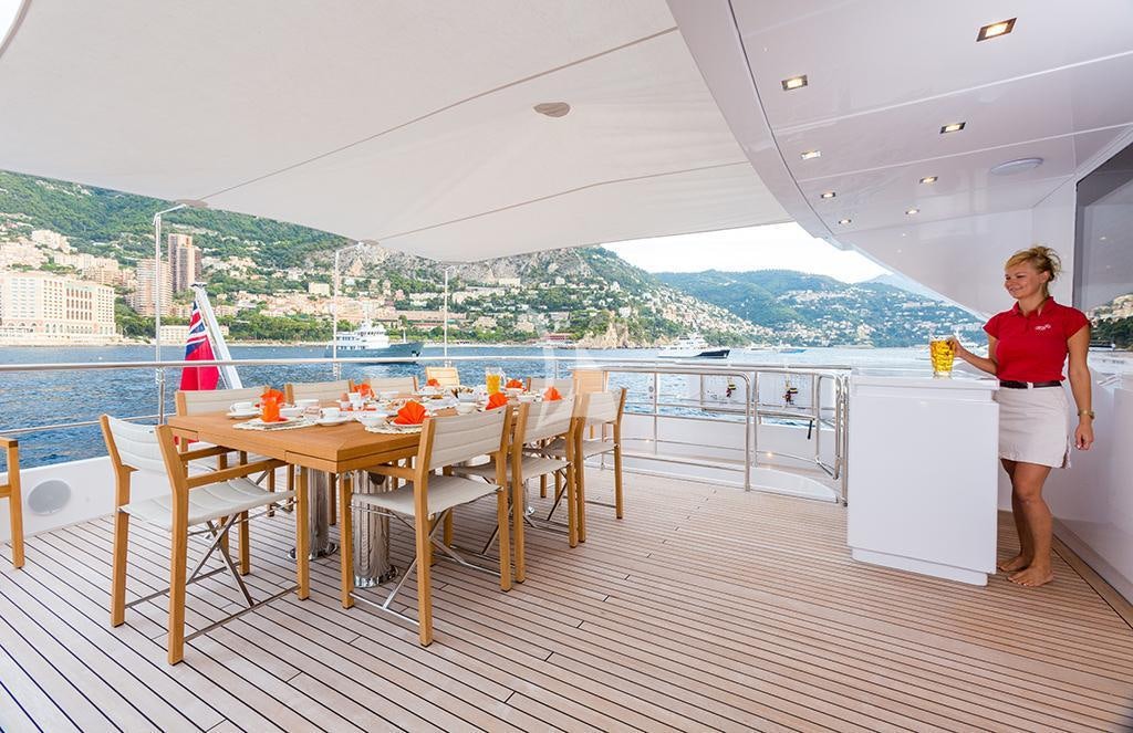 a person standing on a deck overlooking a body of water aboard GATSBY Yacht for Charter