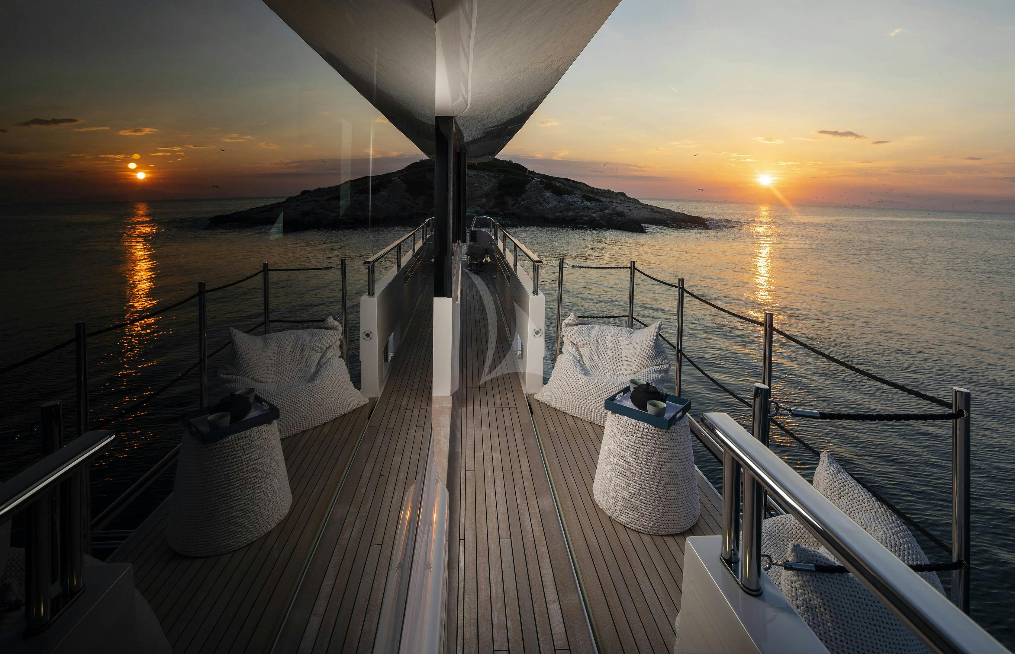 a deck with a view of the sunset and the ocean aboard DINAIA Yacht for Charter