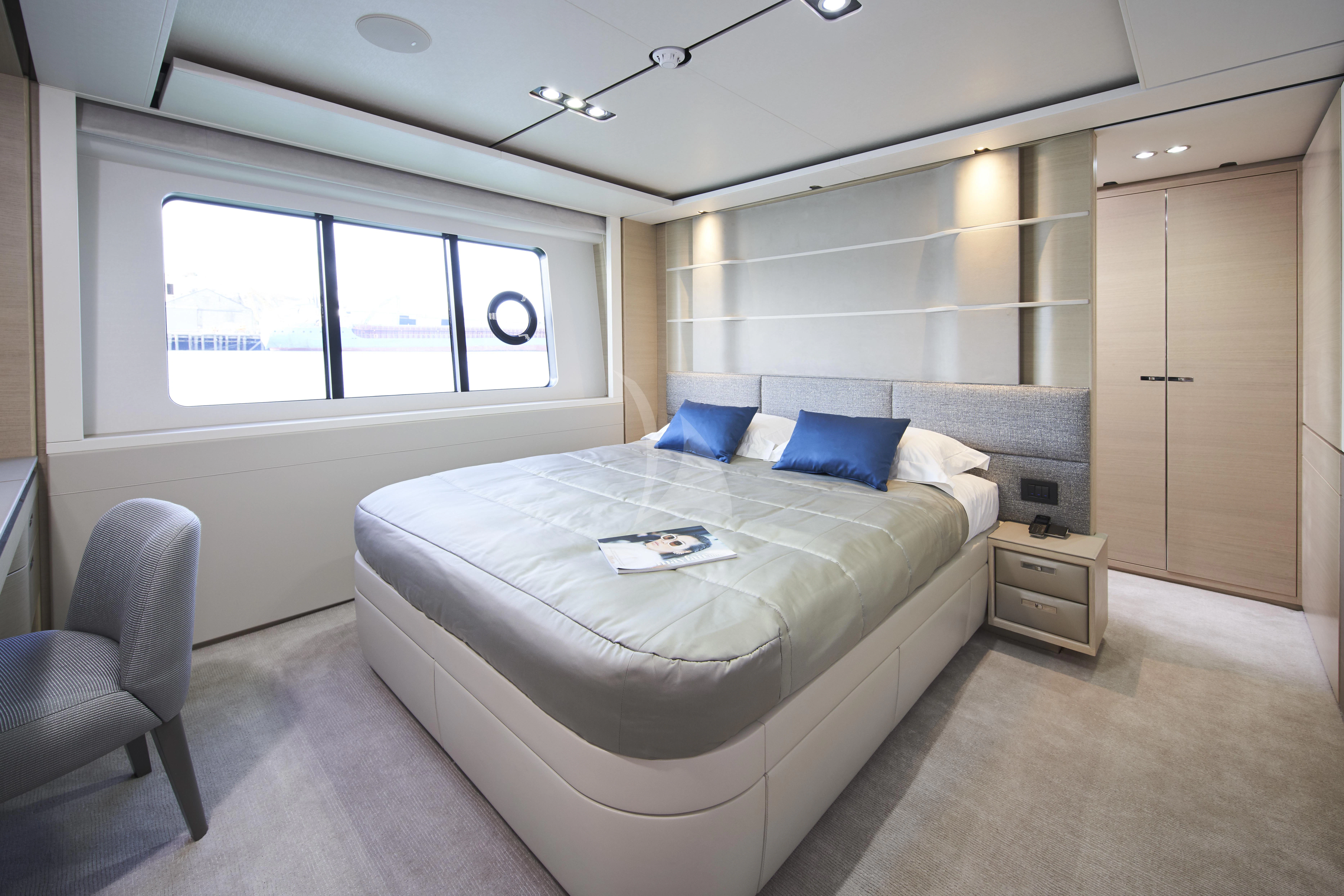 a bedroom with a bed and a chair aboard HALLELUJAH Yacht for Charter