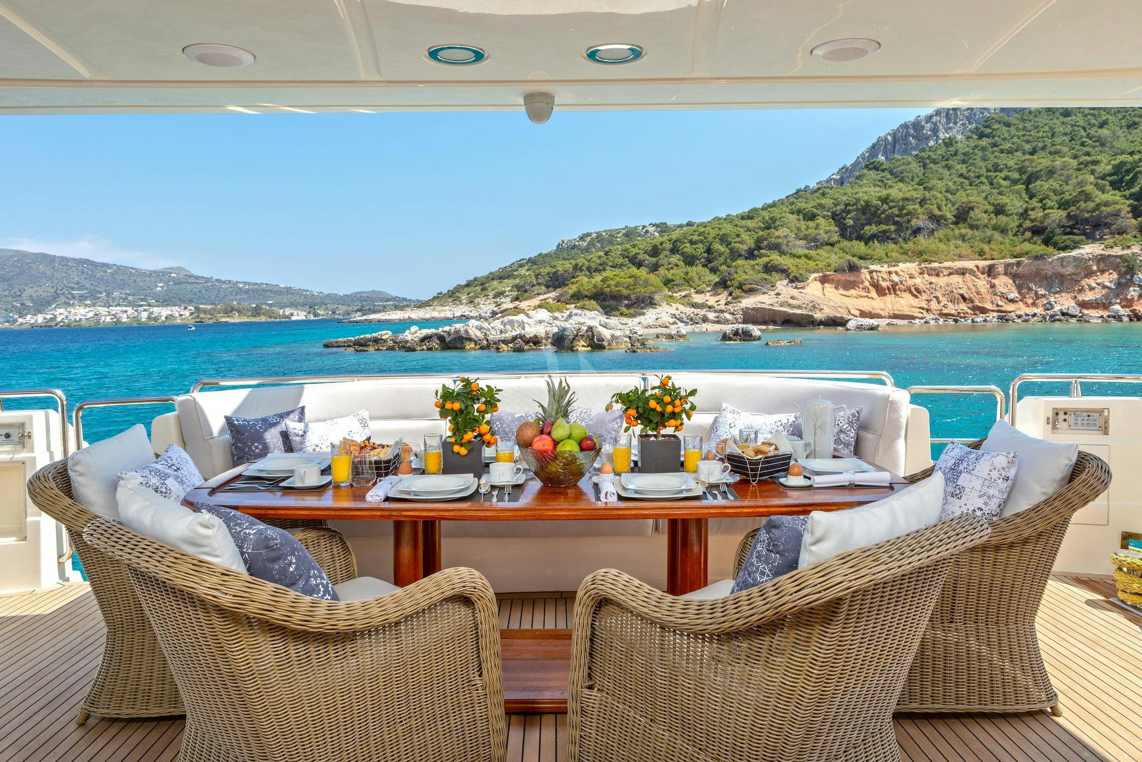 a table with chairs and a view of the ocean aboard DIVINE Yacht for Charter