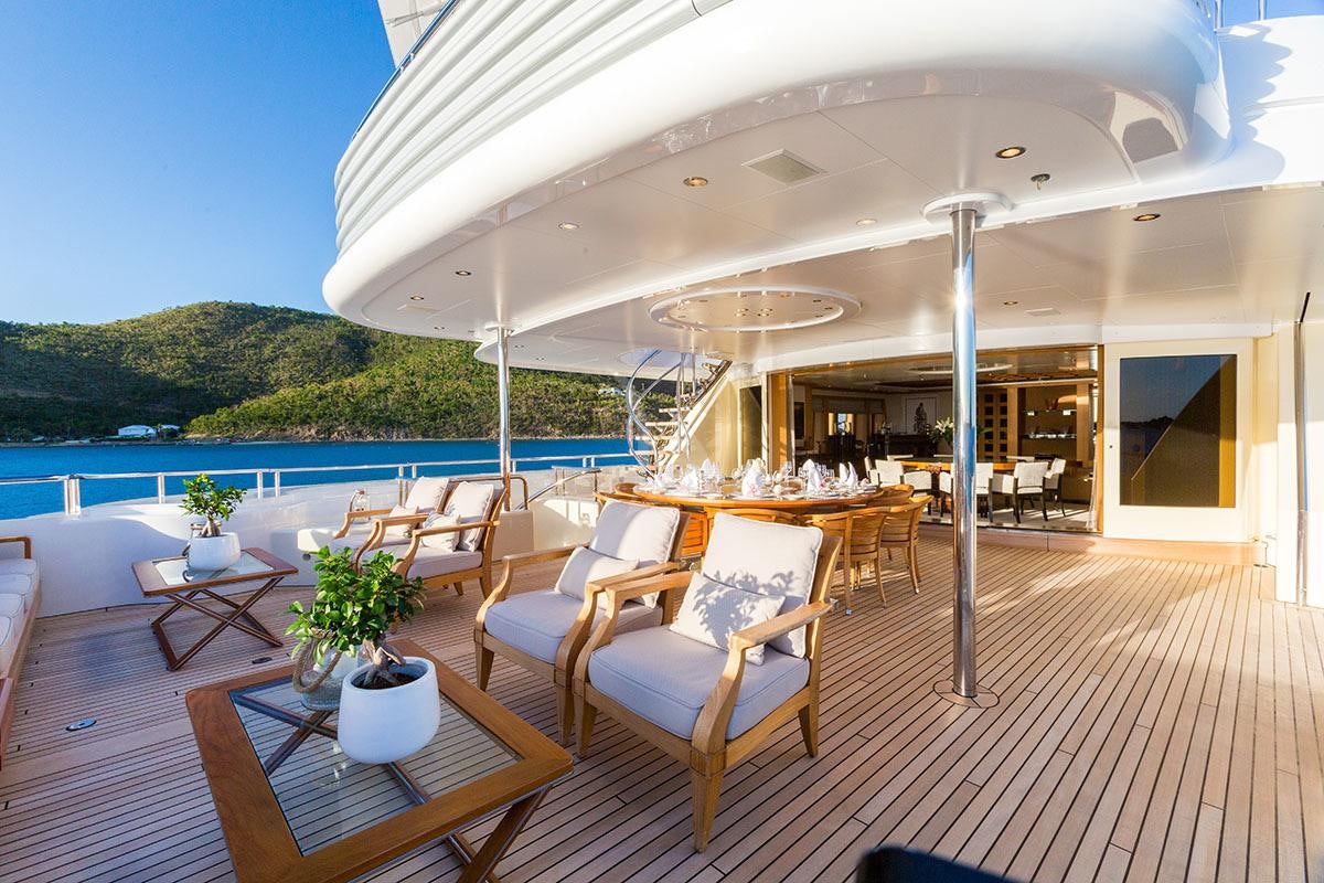 a deck with a table and chairs aboard ADVENTURE Yacht for Charter
