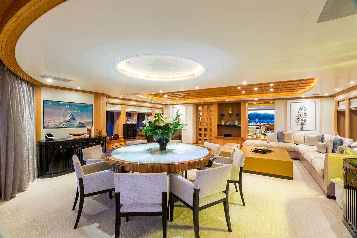 a large living room with a large table and chairs aboard ADVENTURE Yacht for Charter