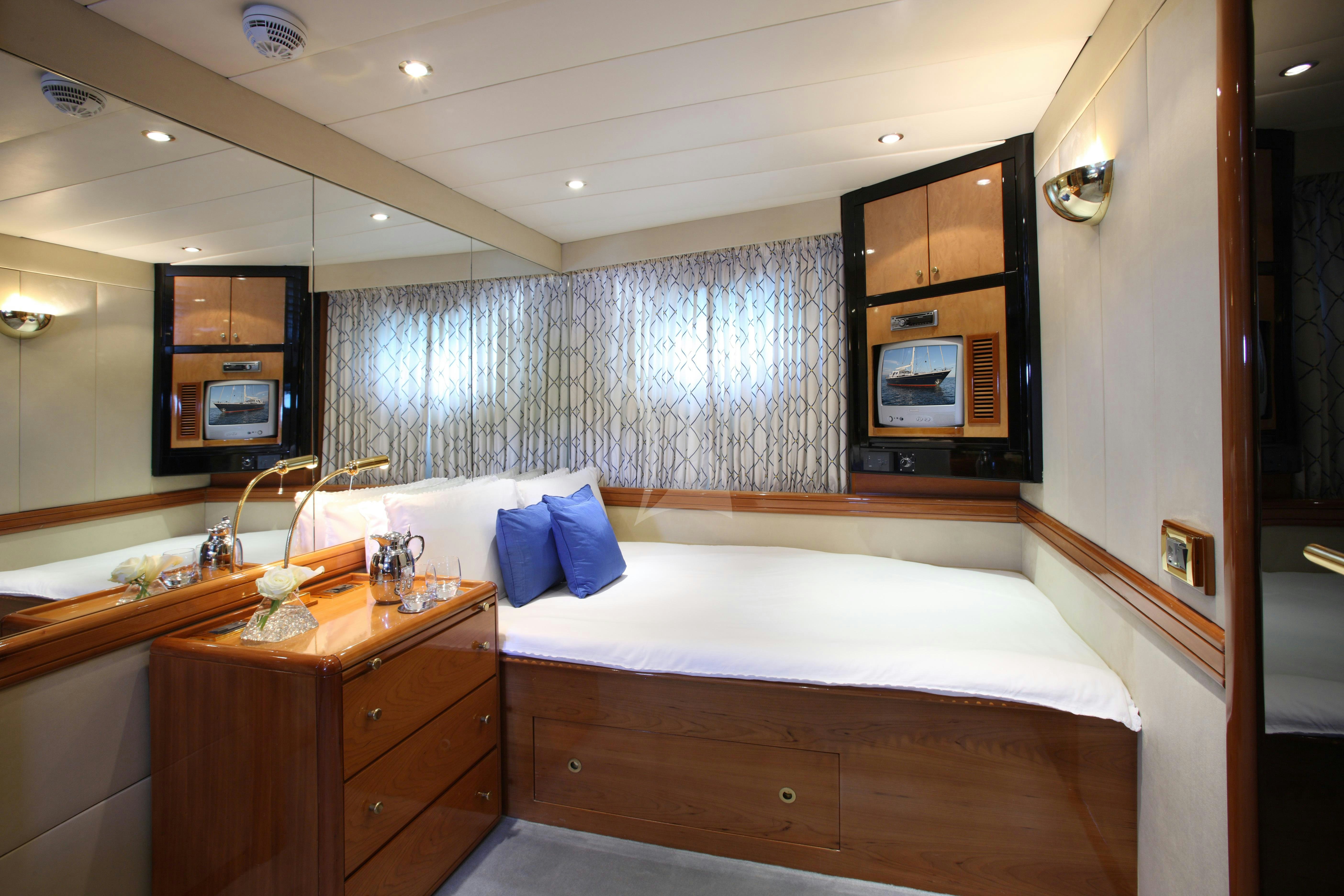 a room with a bed and a television aboard UNPLUGGED Yacht for Charter