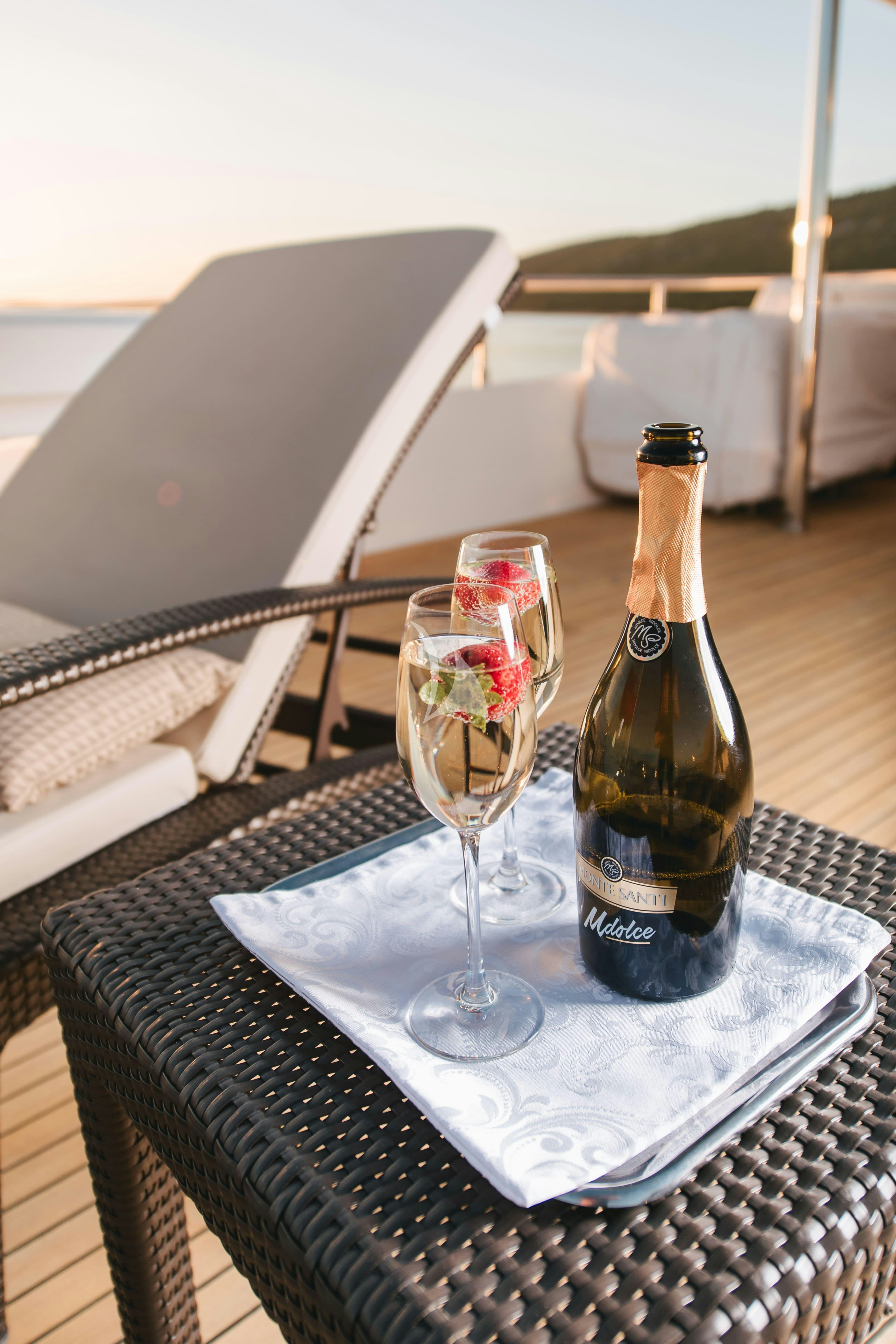a bottle of wine and a glass of wine on a table aboard KLOBUK Yacht for Charter