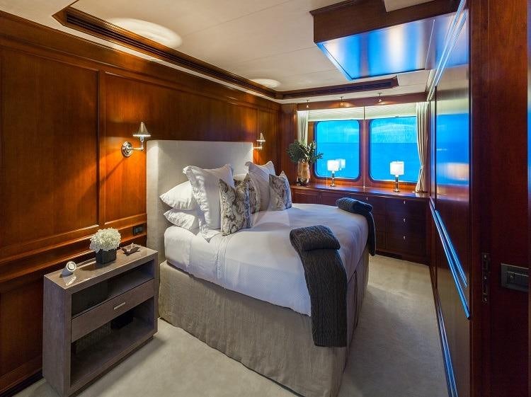 a bedroom with a bed and a desk aboard PIONEER Yacht for Charter