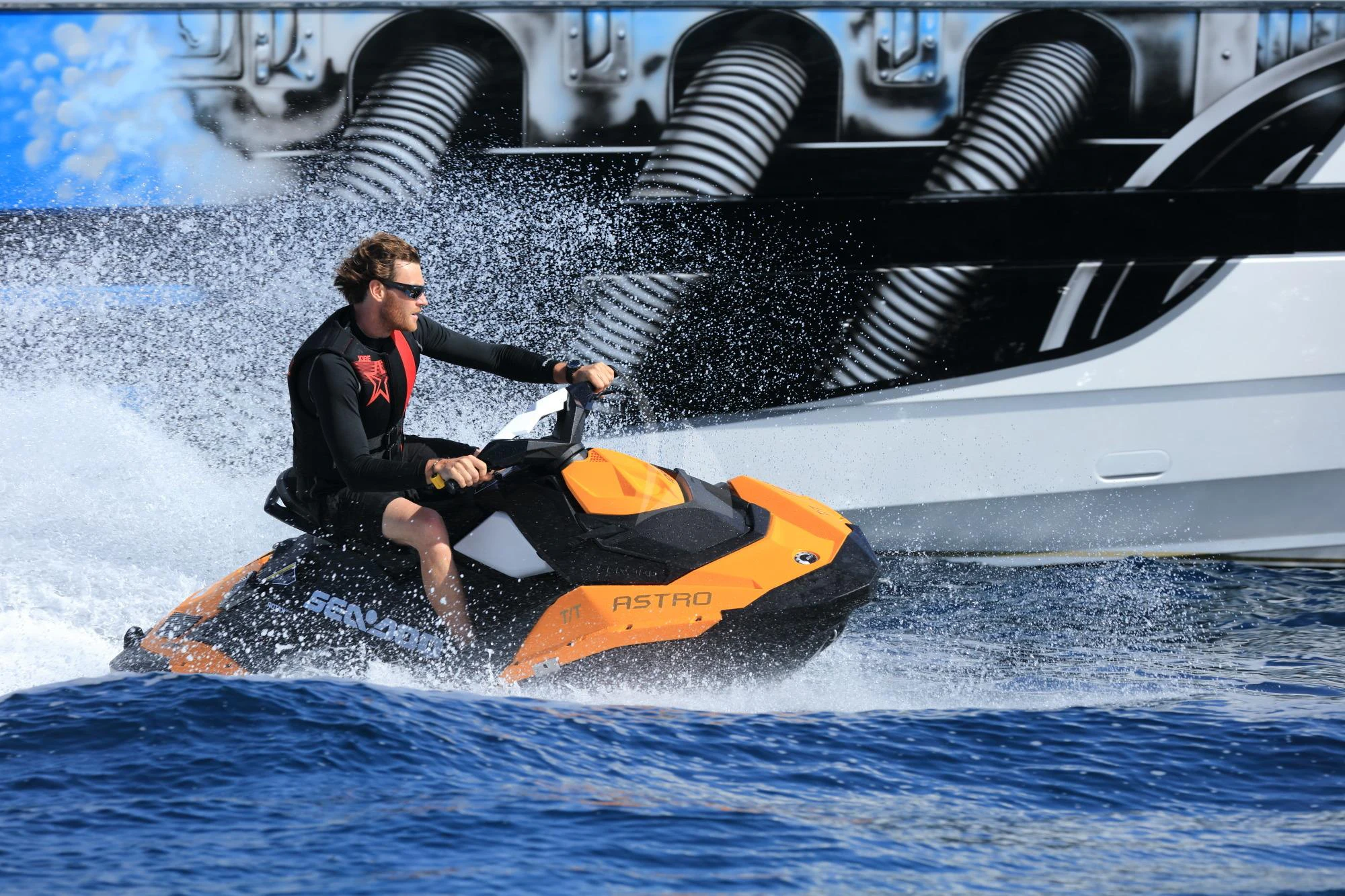 a man riding a jet ski aboard ASTRO Yacht for Charter