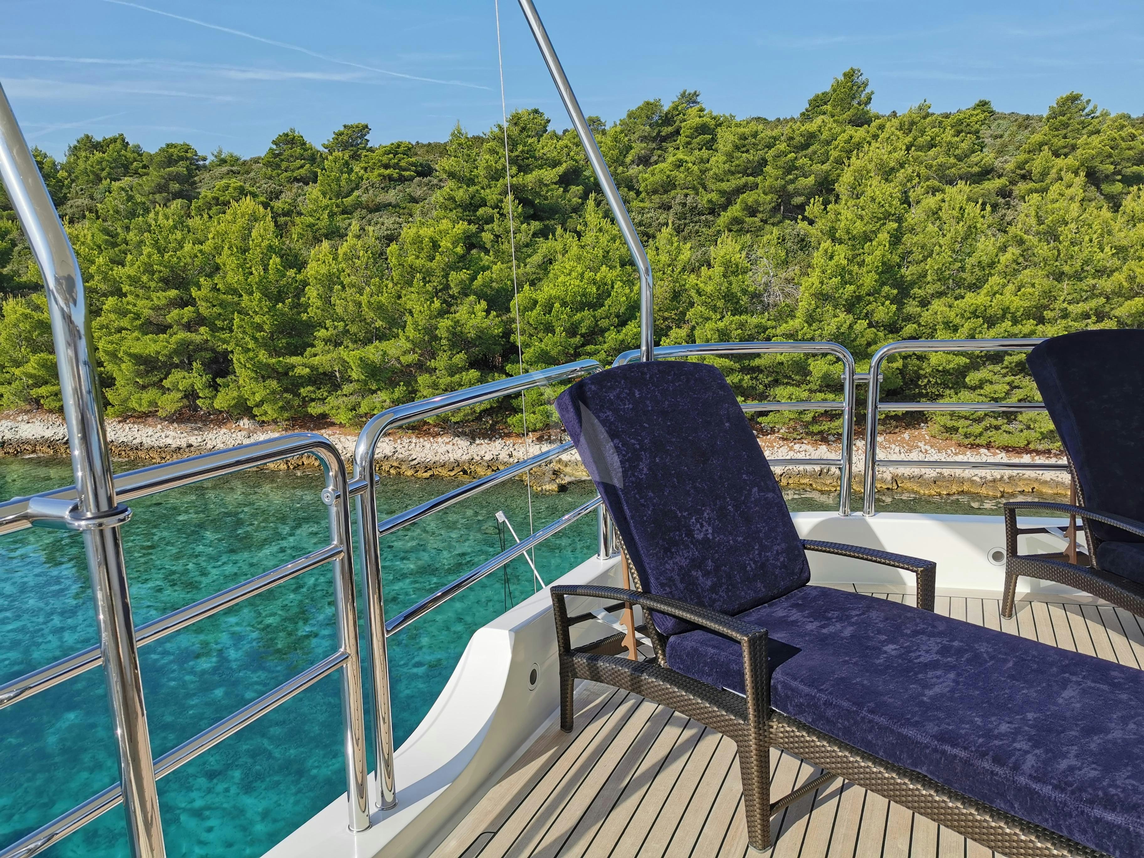a chair on a balcony aboard HARMONY III Yacht for Charter
